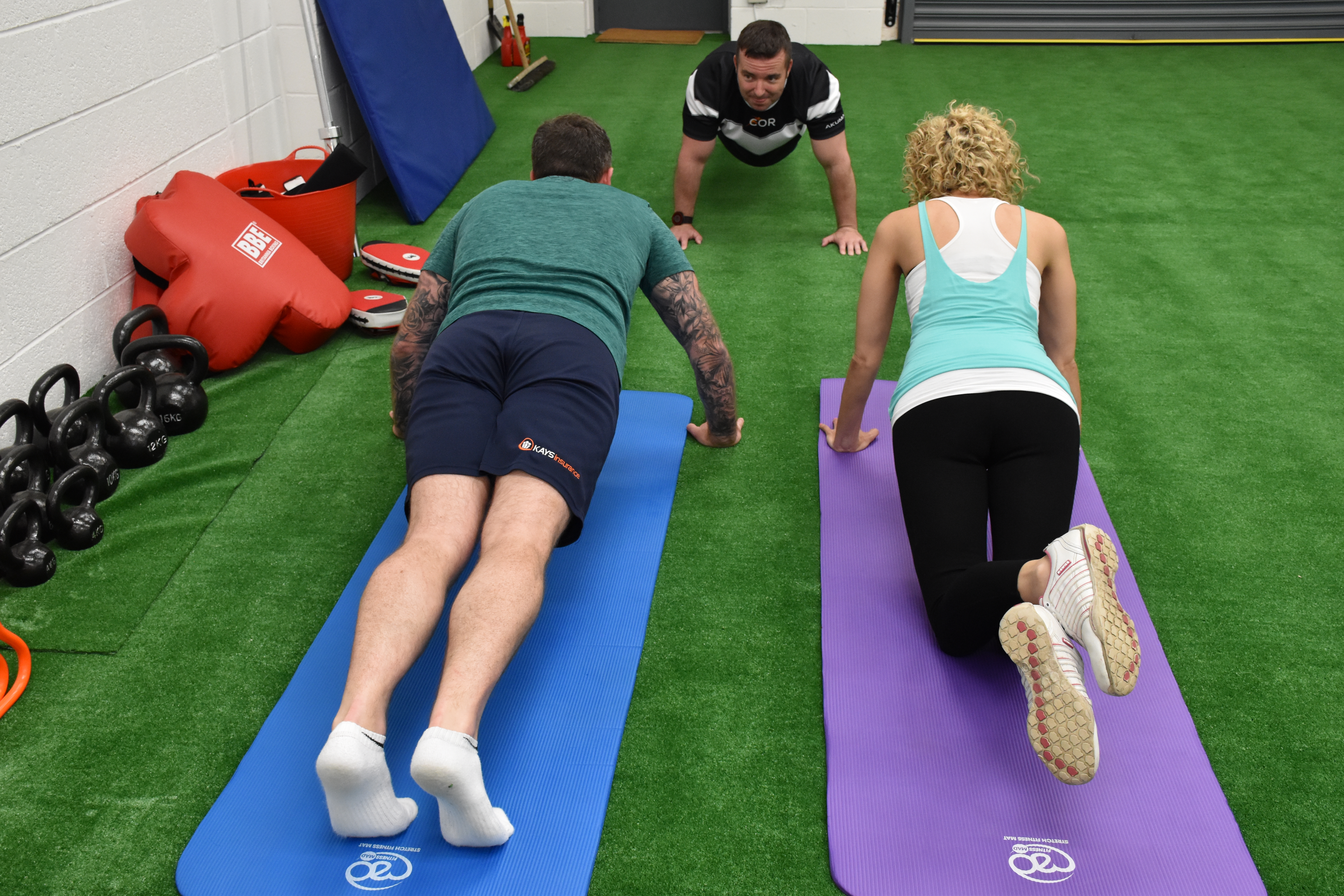 Personal trainer Chris O'Rourke explains exercises to clients lying on gym mats(Chris O'Rourke/PA)