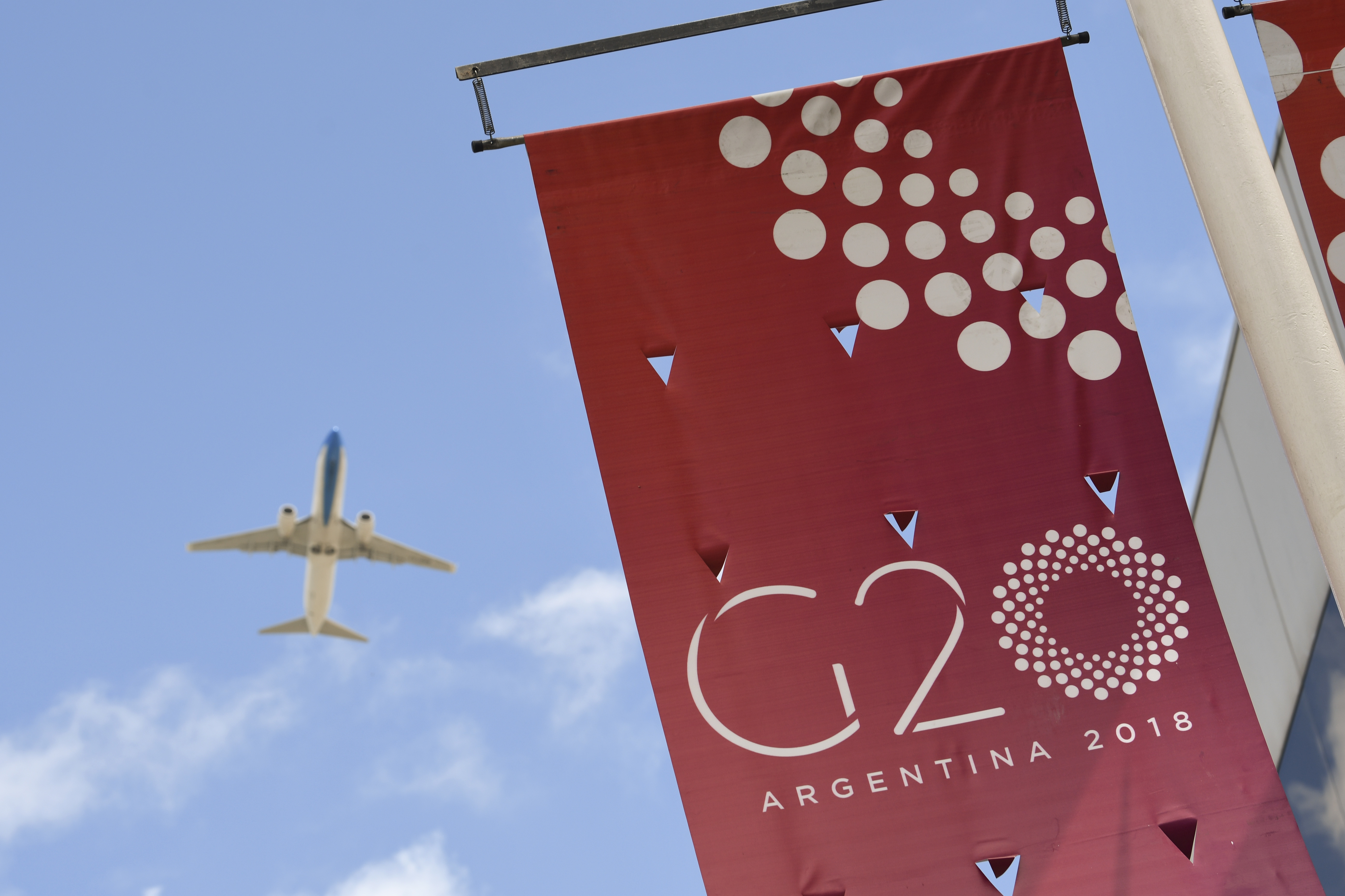 A plane flies over the G20 summit venue at the Costa Salguero Centre in Buenos Aires, Argentina