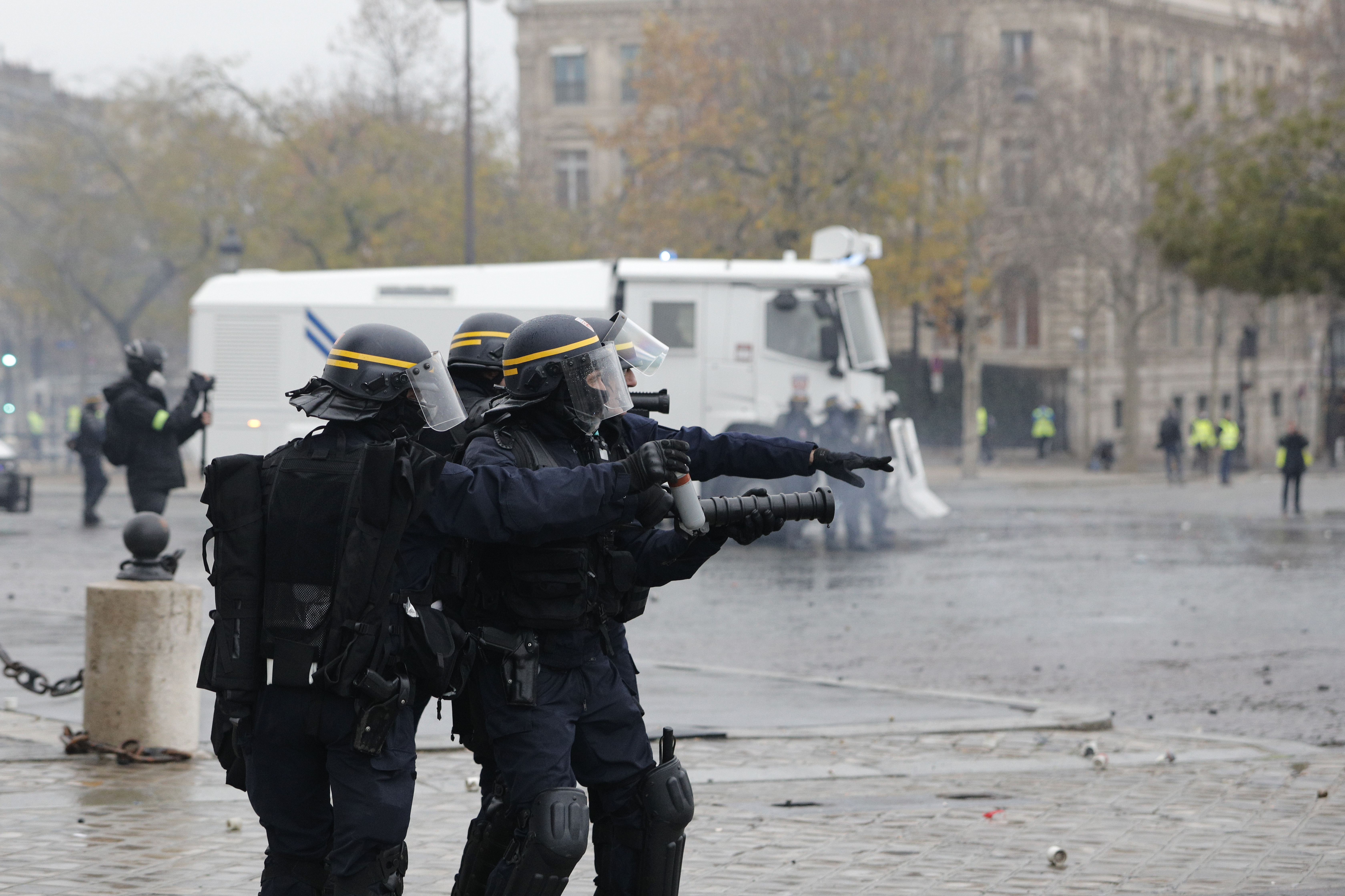 Riot police officers take up their position near the Arc de Triomphe during a demonstration