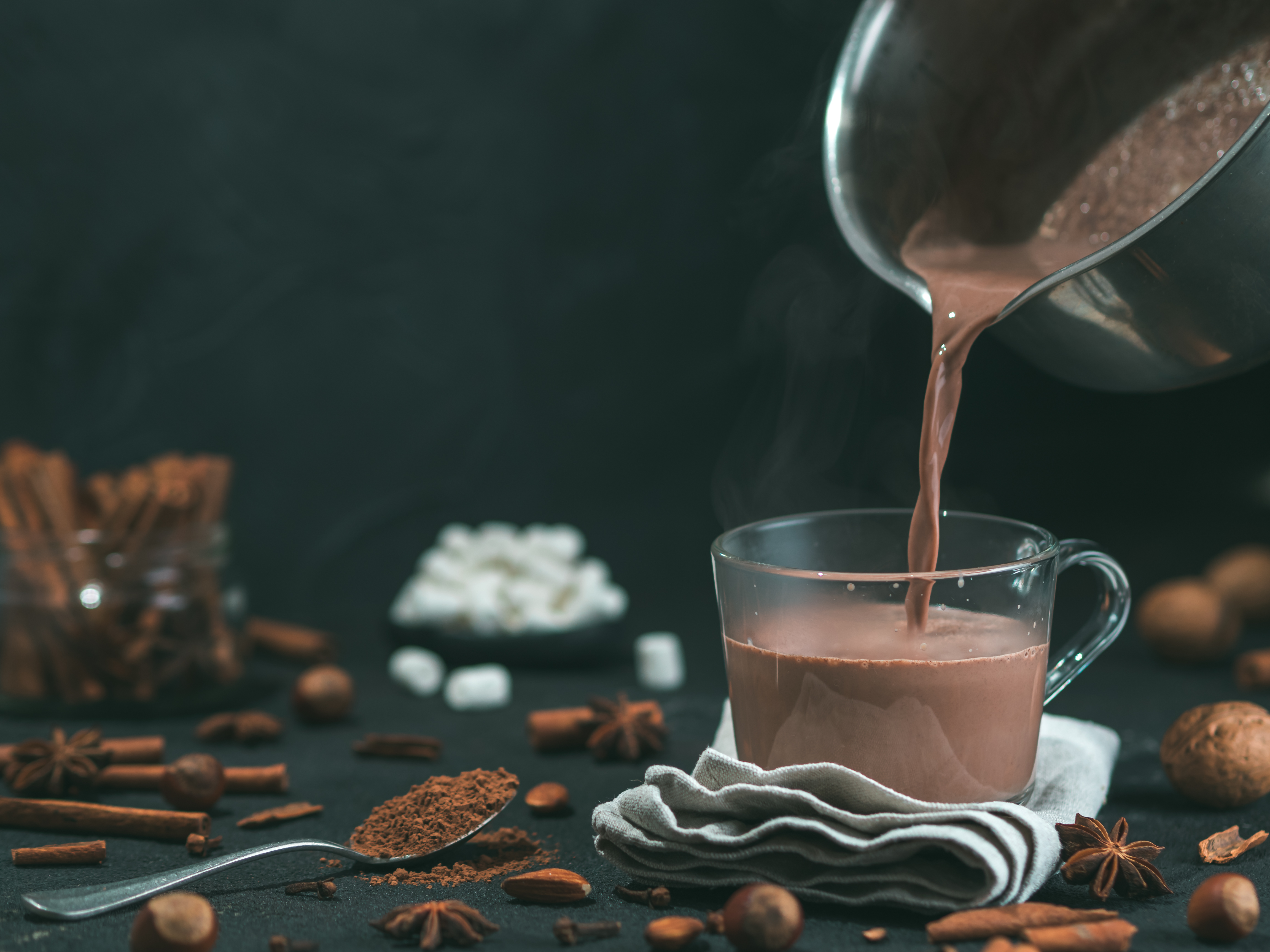 Pouring hot chocolate from a pan to a cup