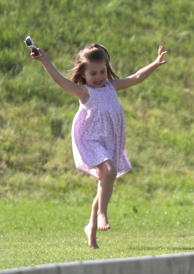 Charlotte playing on the grassy bank at the polo