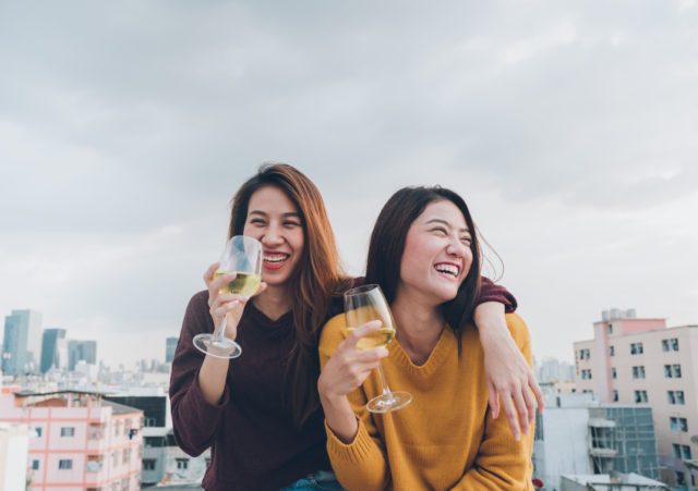 Happy asia girl friends enjoy laughing and cheerful sparkling wine glass at rooftop party,Holiday celebration festive,teeage lifestyle,freedom and fun.lesbian couple