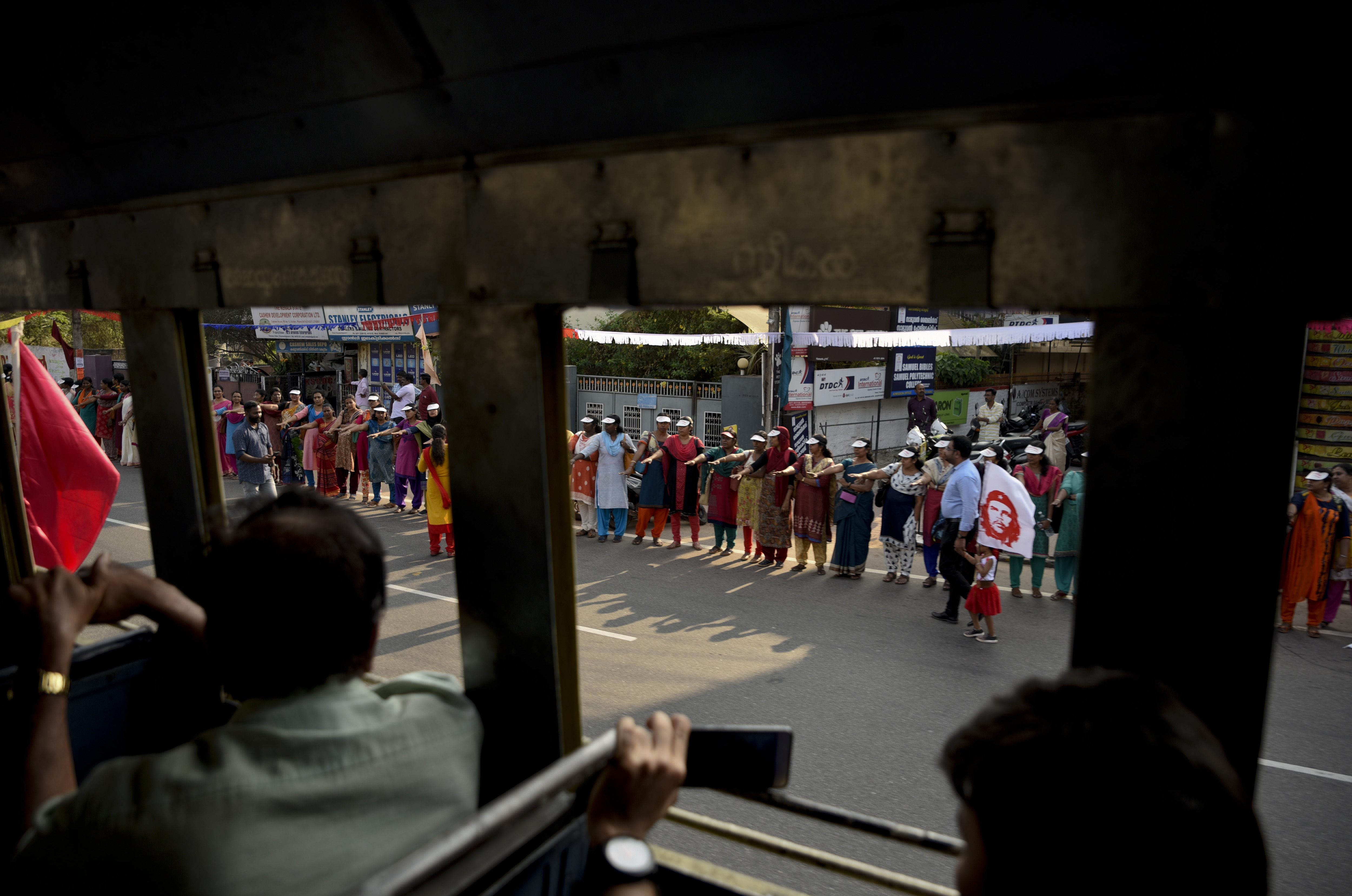 Women raise their hands to take a pledge to fight gender discrimination as they form part of a 'women's wall' in Thiruvananthapuram, in the southern Indian state of Kerala
