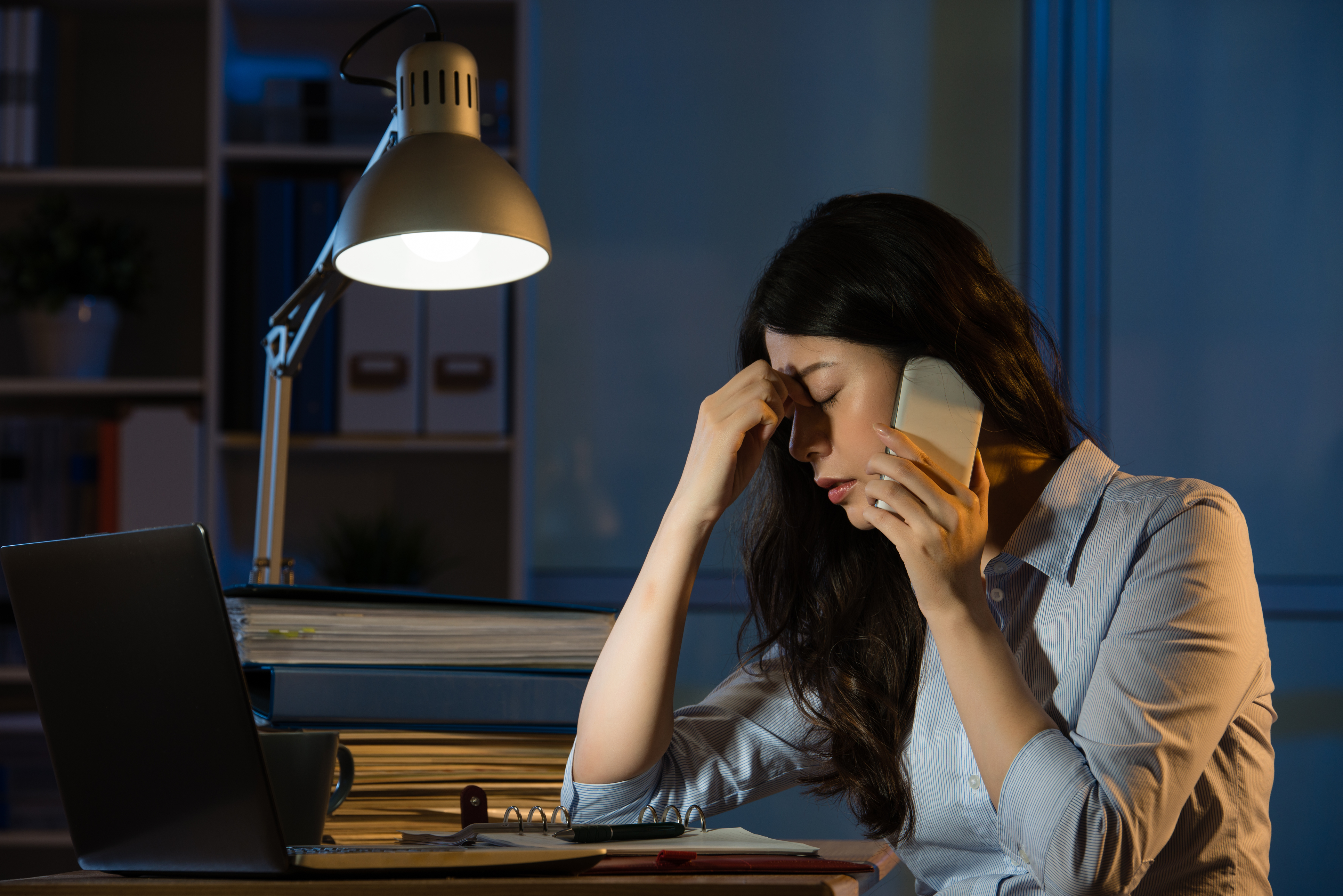Woman at work late at night, stressed
