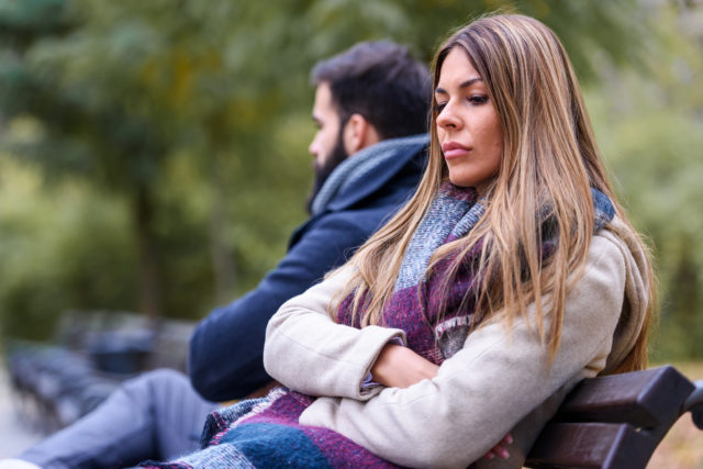Couple sitting in park having relationship problems. Break up