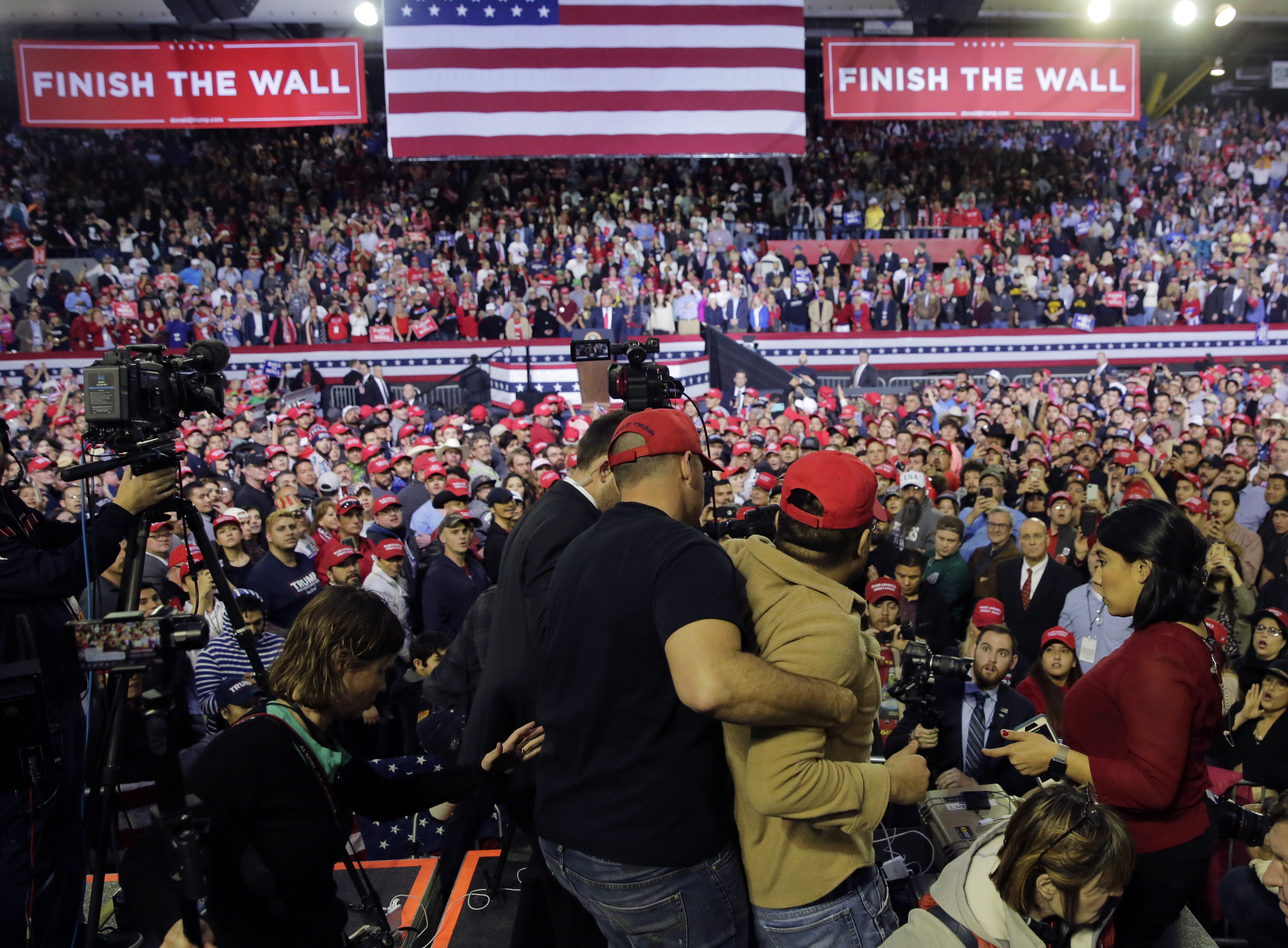 A man is restrained after he began shoving members of the media during a rally for President Donald Trump in El Paso, Texas