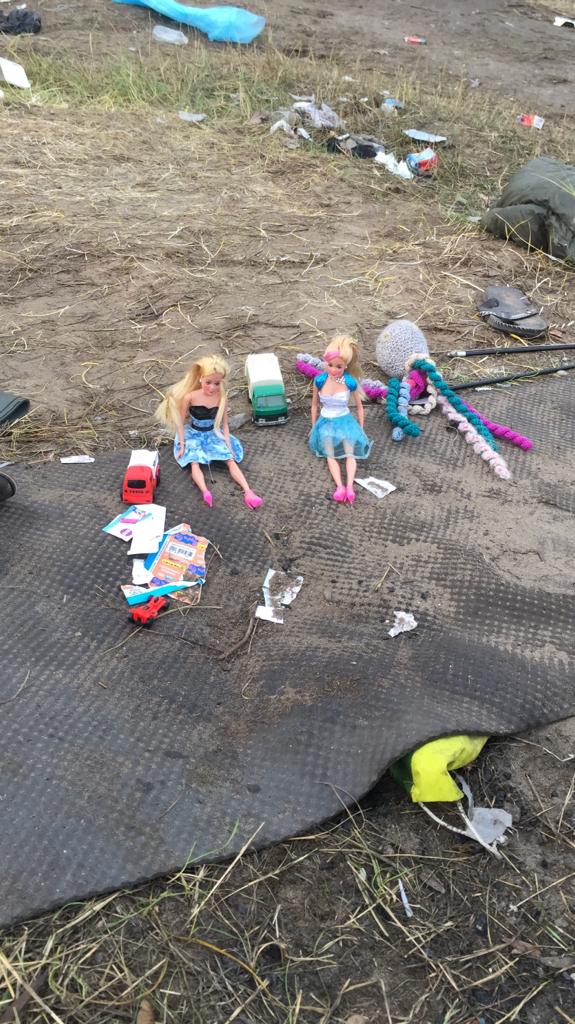 Dolls lie scattered on the muddy ground in Calais (PA)