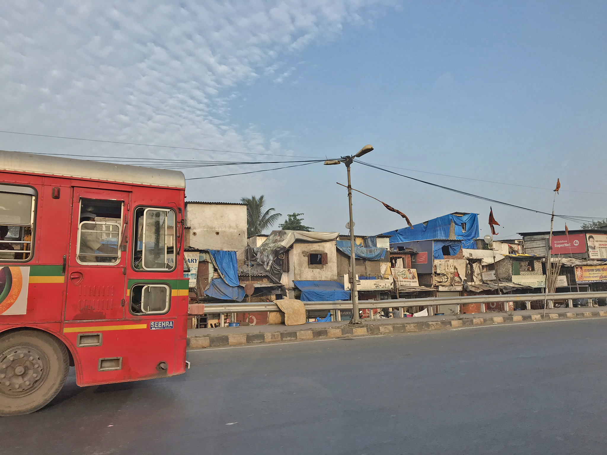 A bus drives past one of Mumbai’s many slums (Harriet Line/PA)