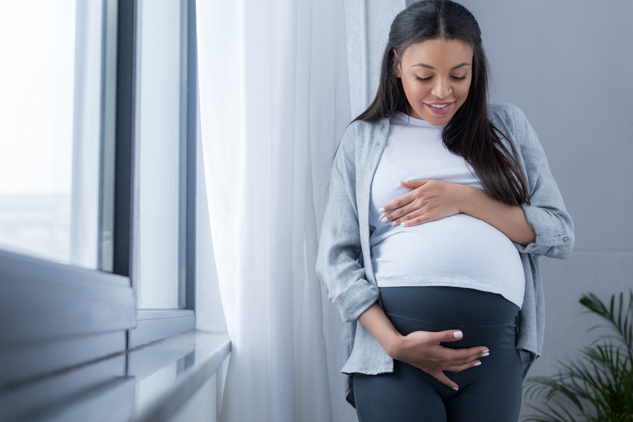 pregnant woman looking at her belly