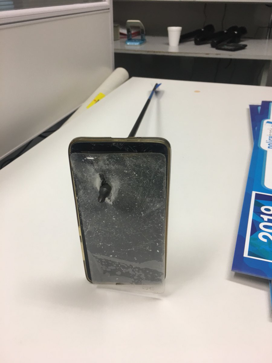 A mobile phone pierced by an arrow
