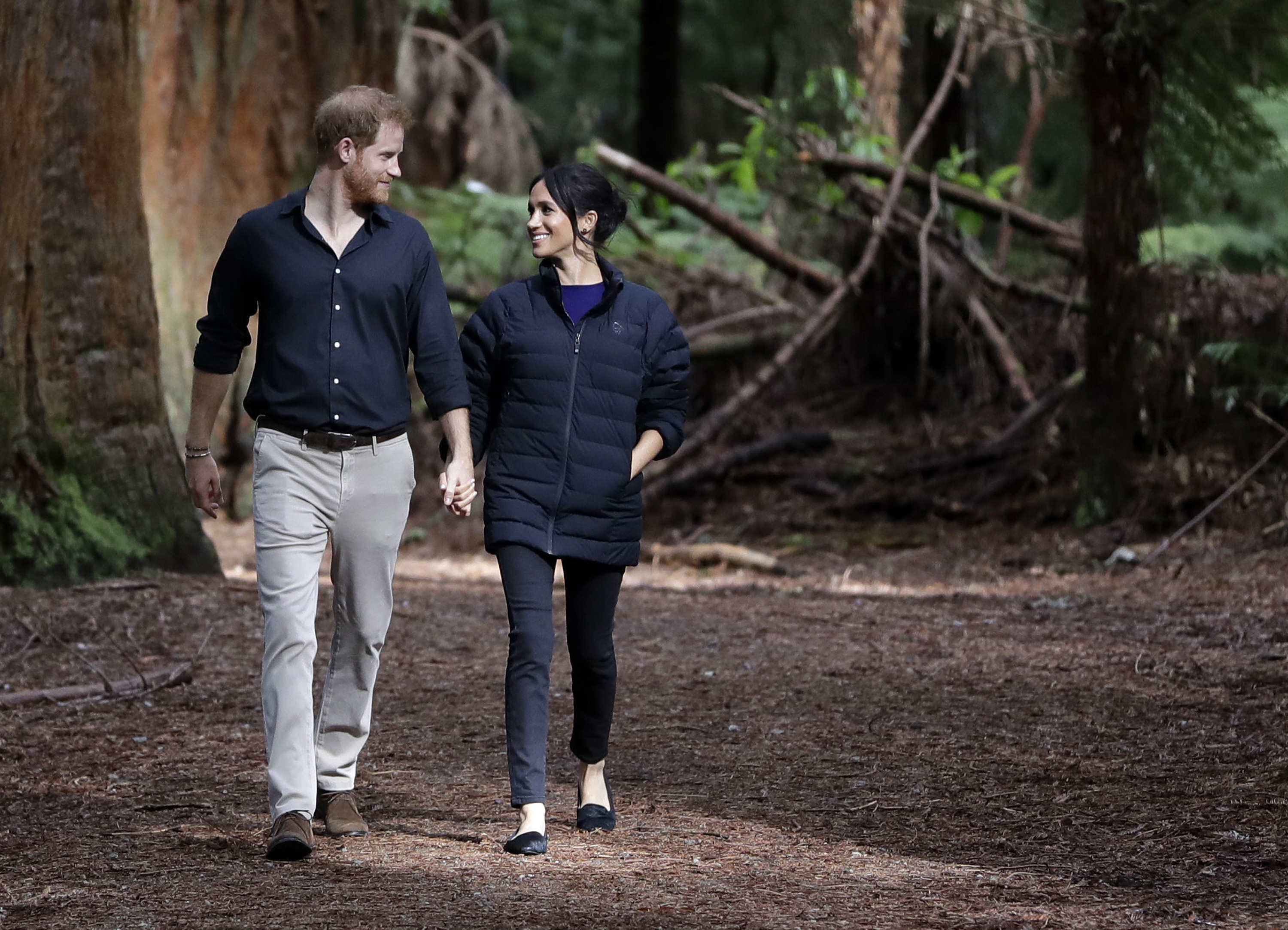 The Duke and Duchess of Sussex walking through a forest during a visit to Redwoods Tree Walk and Mountain Biking Showcase in Rotorua, New Zealand