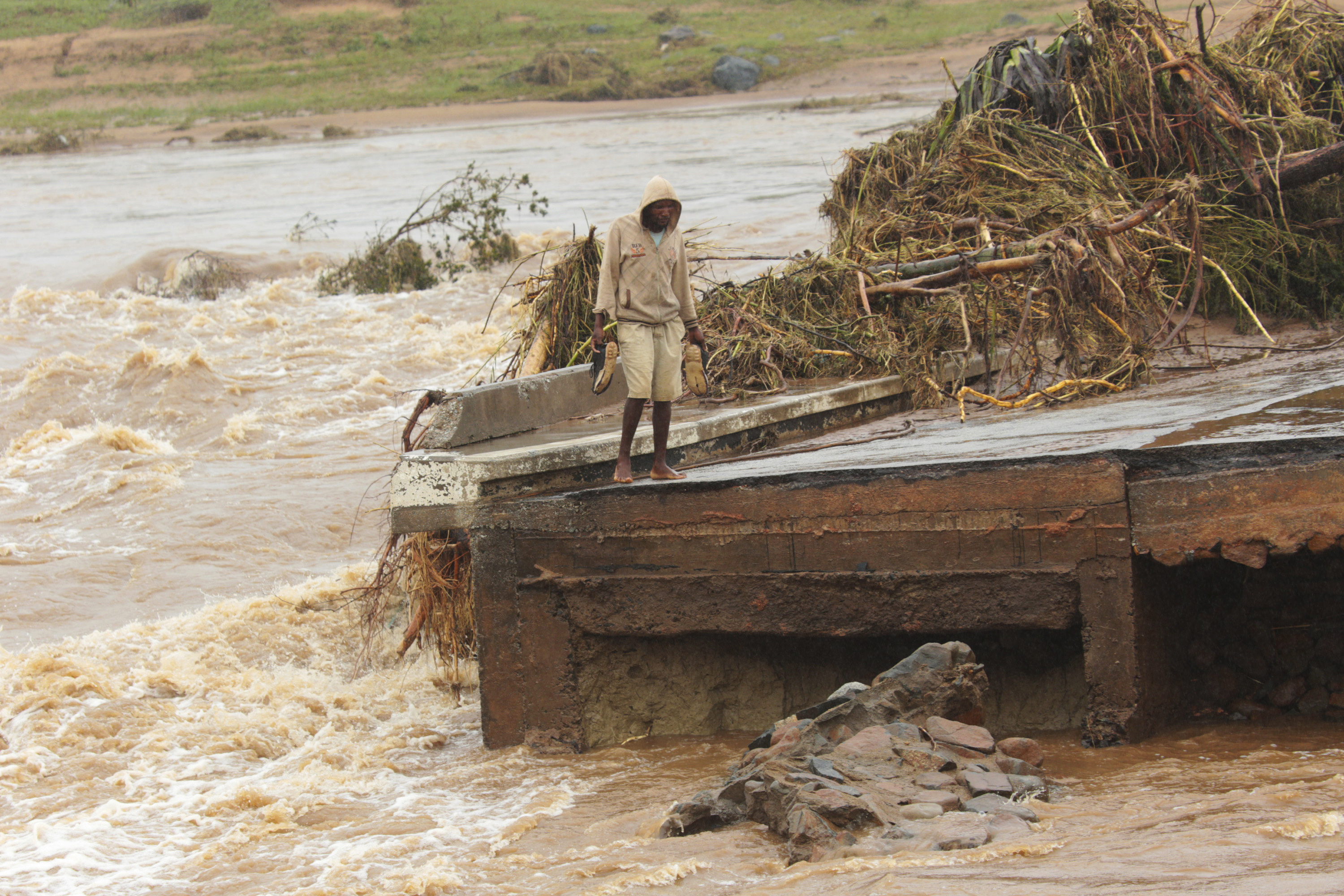 A man stands on the edge of a collapsed bridge in Chimanimani, about 600km south east of Harare, Zimbabwe