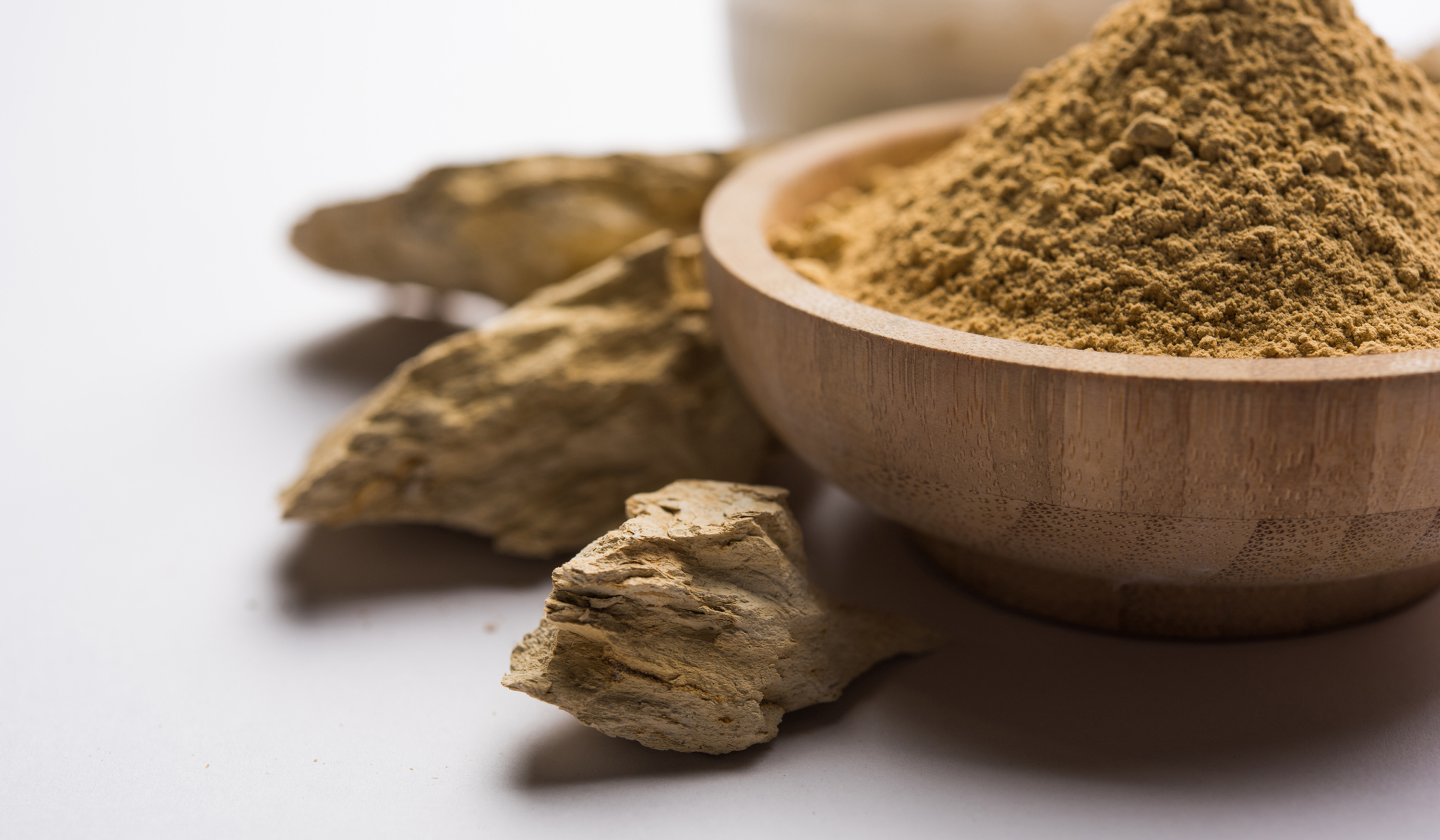 Fuller'S Earth Clay OR Multani mitti in a bowl along with raw stones and mortar