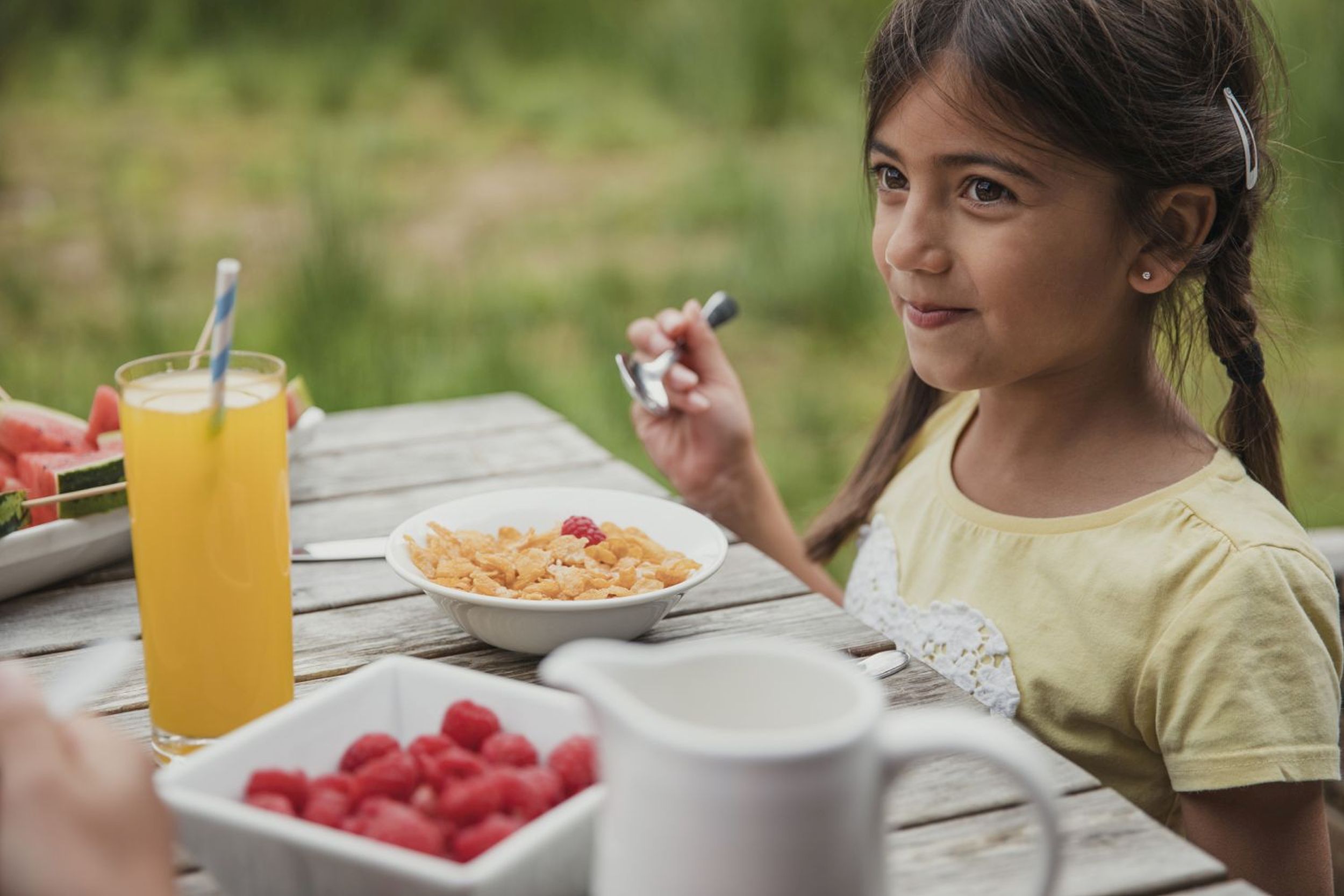 Little girl smiling as he eats her cereal outside (iStock/PA)