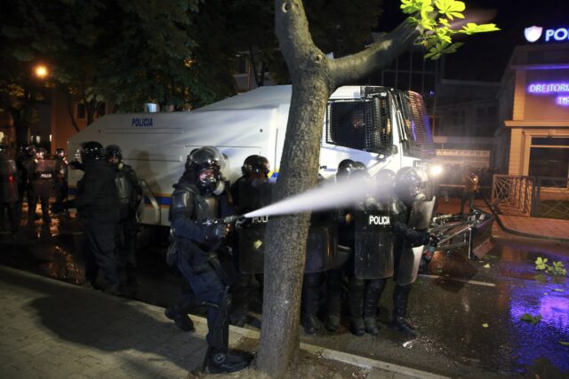 Riot police spray tear gas at protesters