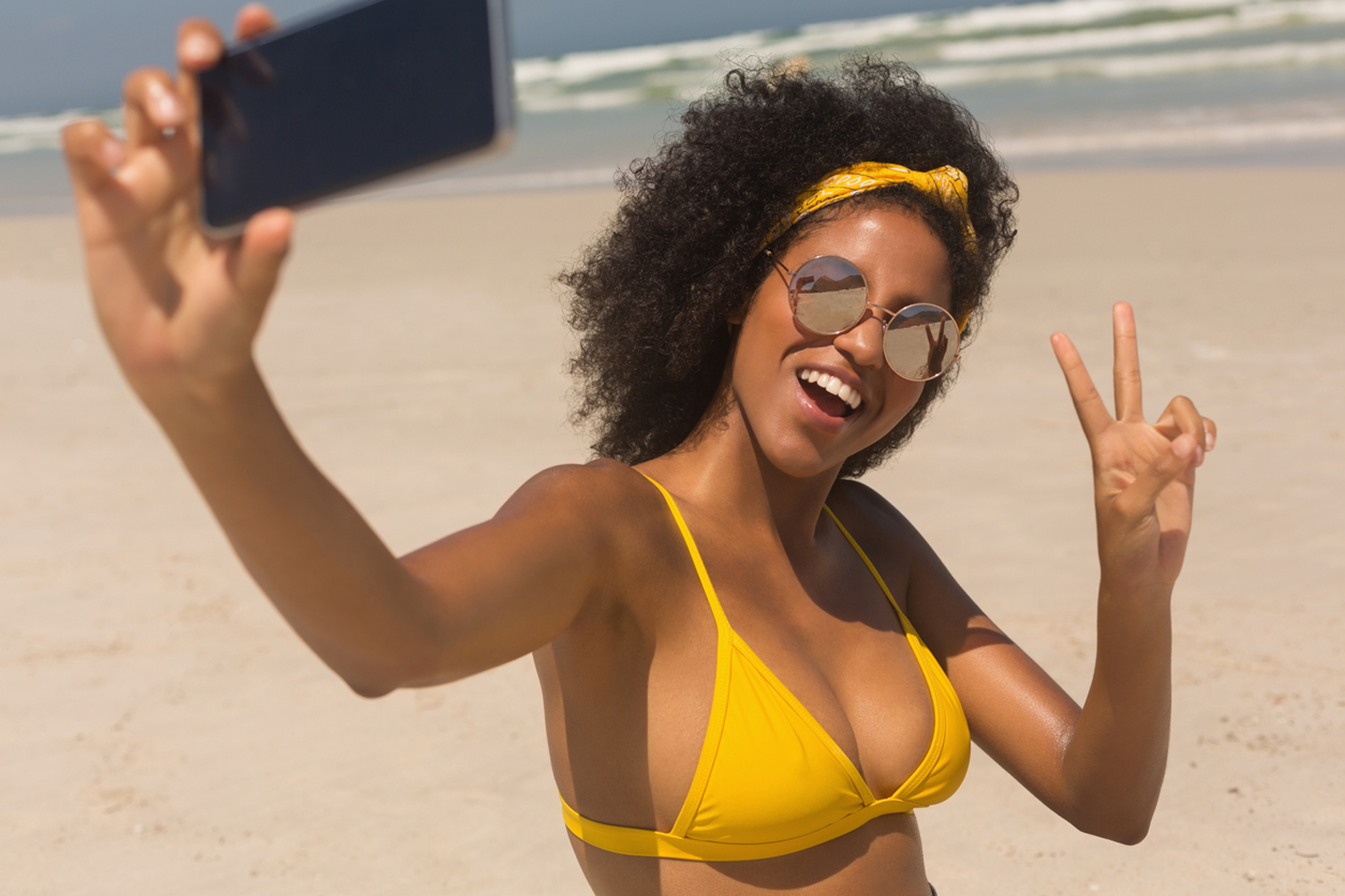 woman on a beach taking a selfie