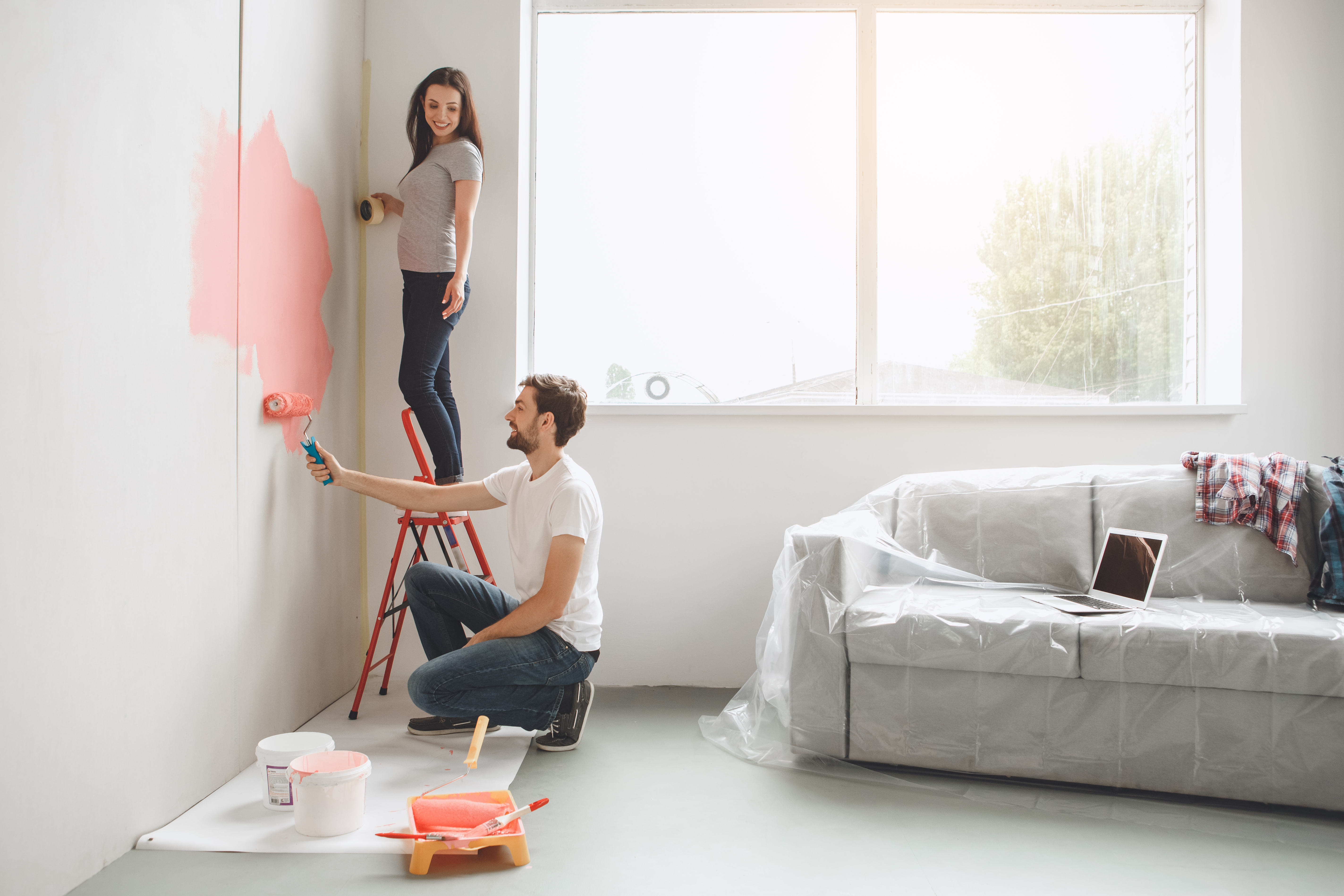 Couple repainting a wall