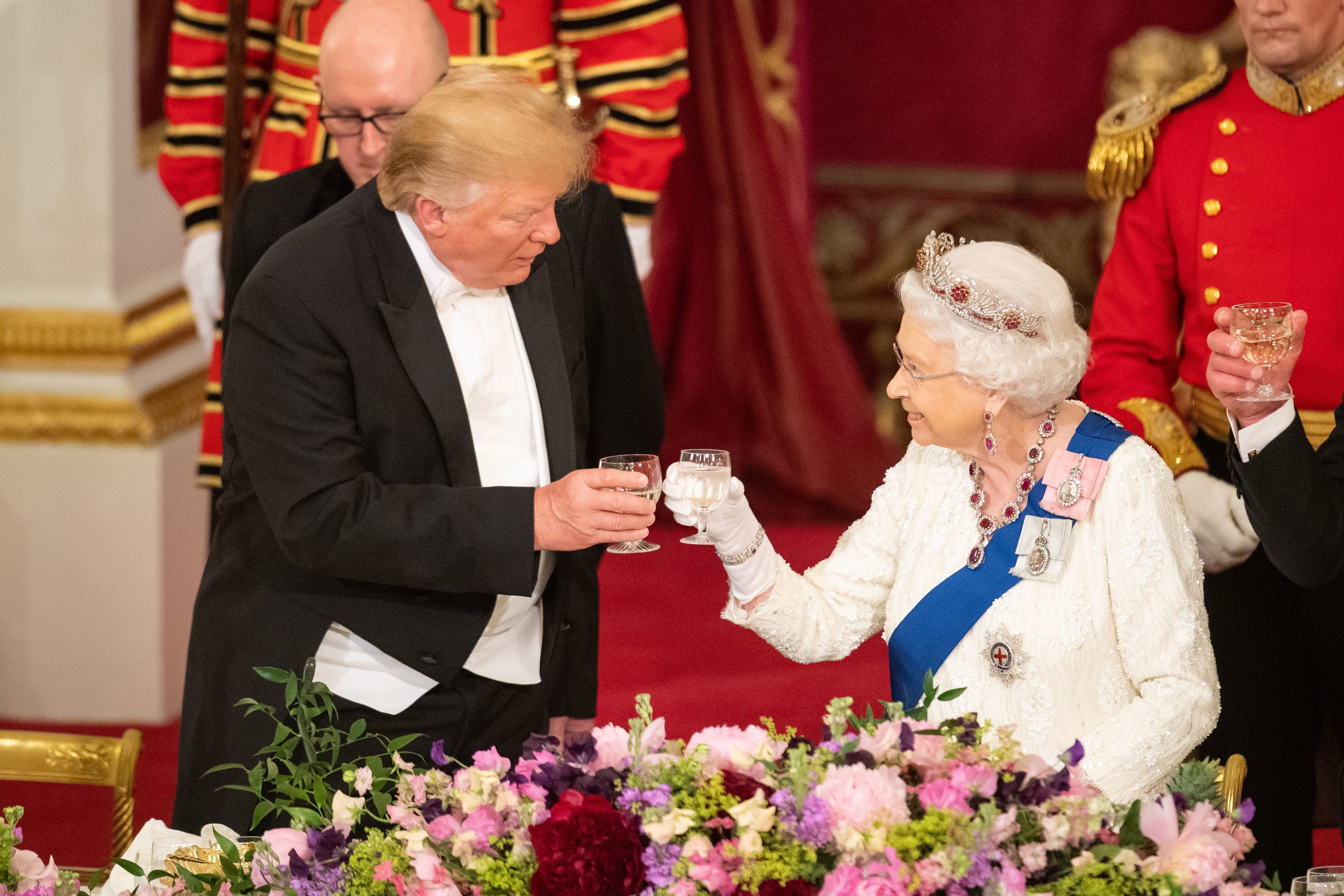 Mr Trump touches glasses with the Queen