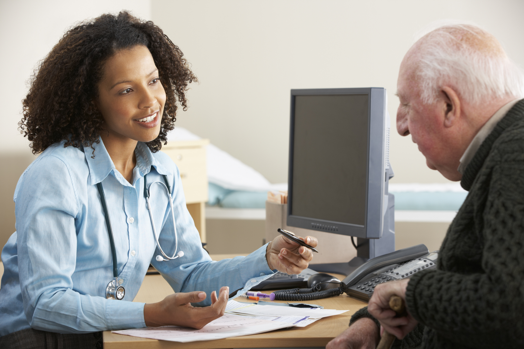 Smiling young female Doctor with senior male patient.