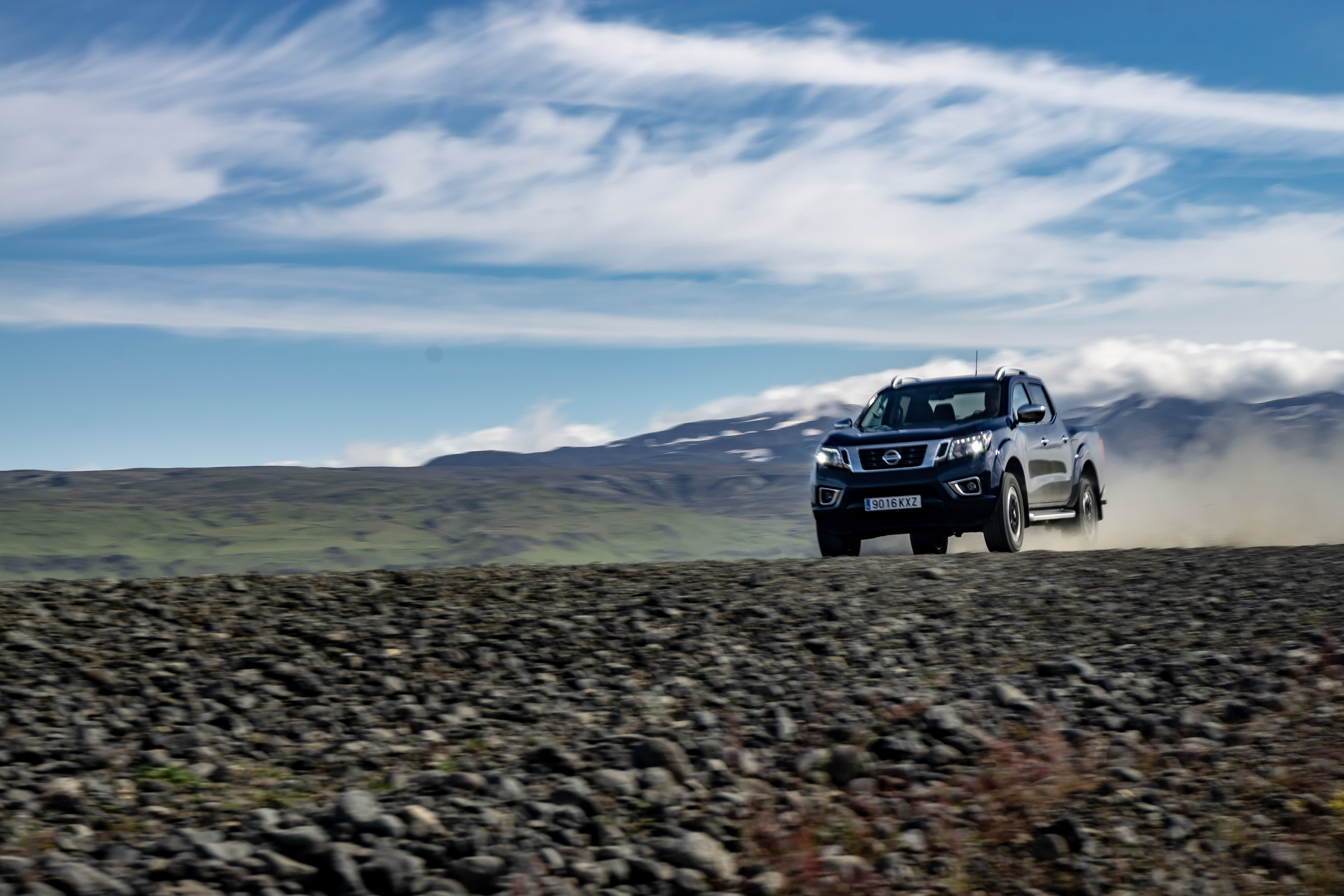 The Navara kicks up a huge plume of dust as it hammers along a track