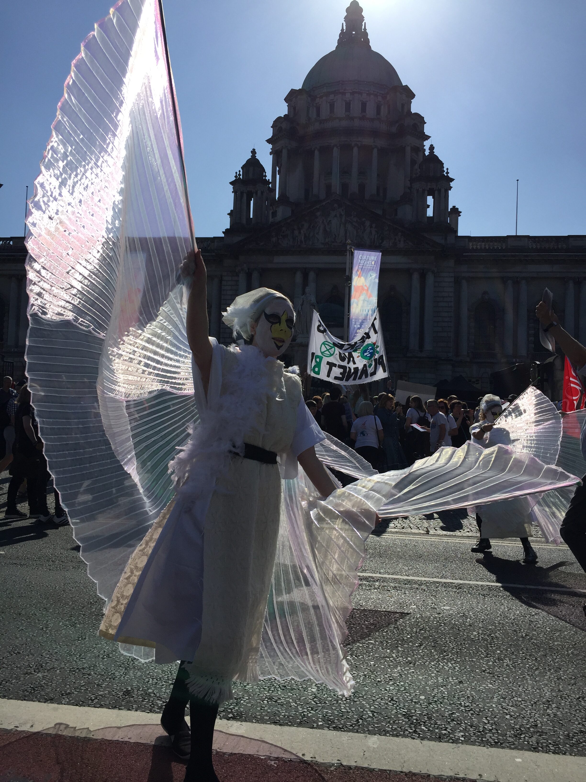 An activist dressed as a swan dances in front of City Hall 