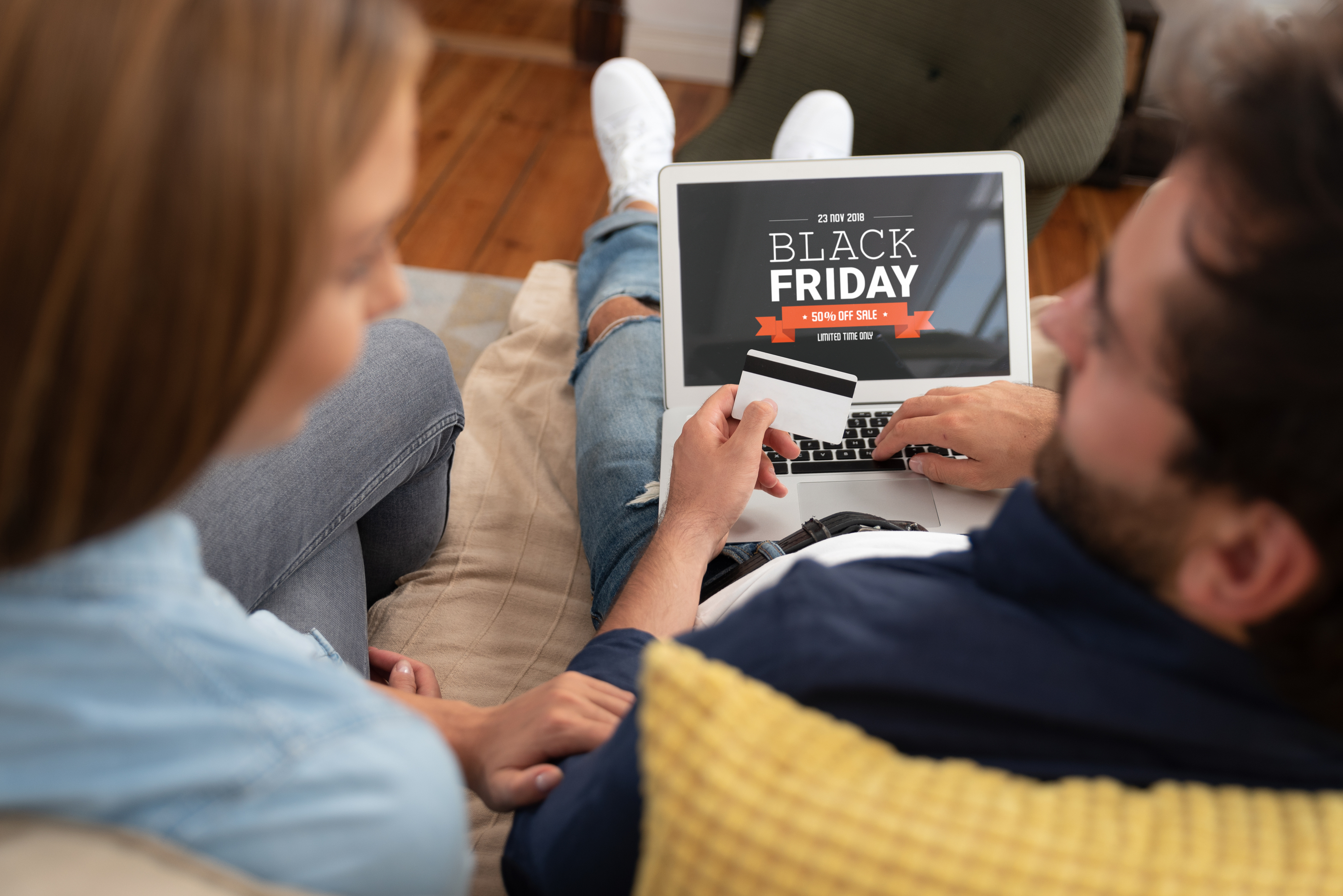 Black Friday promotion sale on laptop screen. Young couple doing shopping class=
