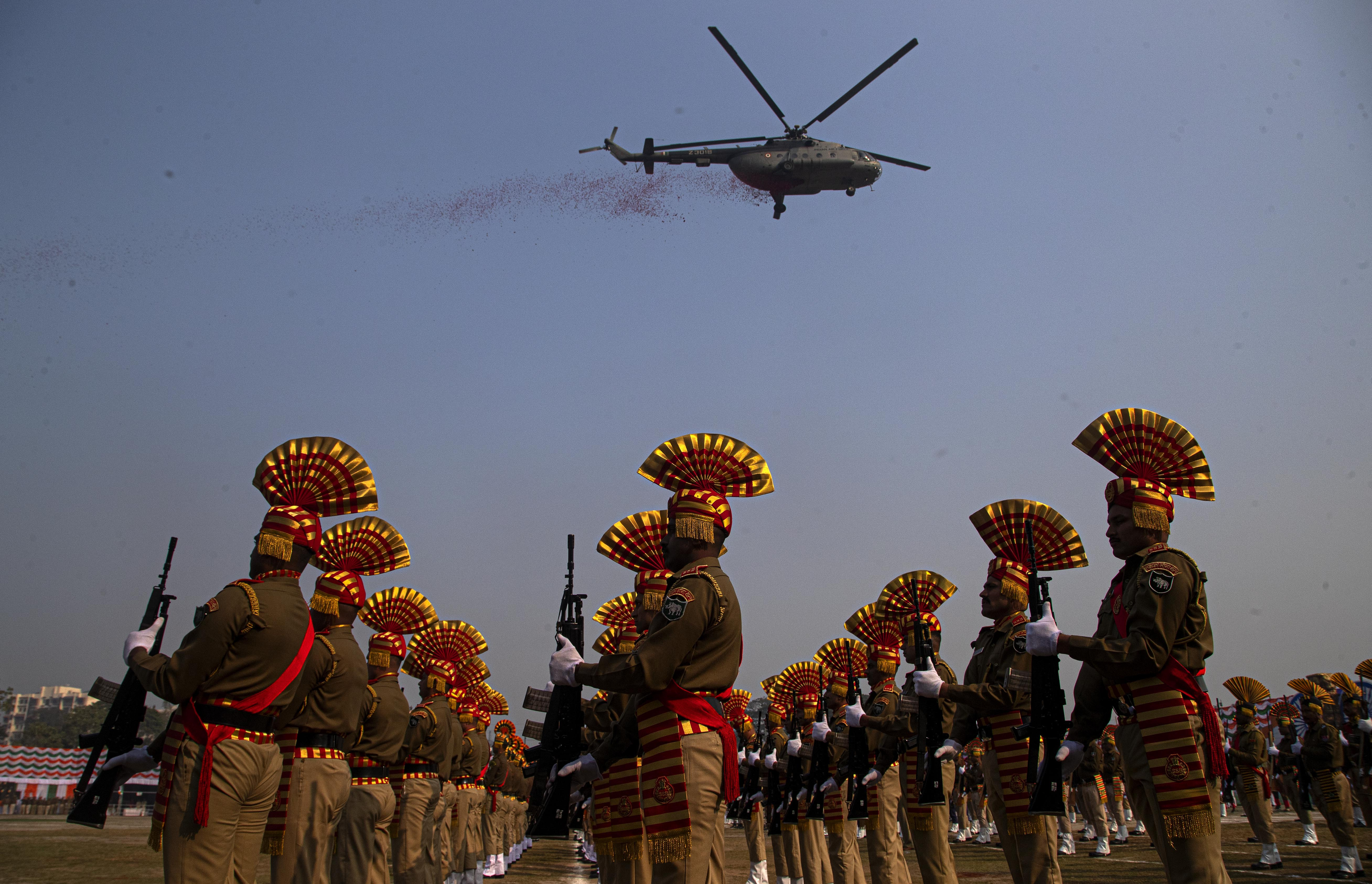 Helicopter flies over marching soldiers