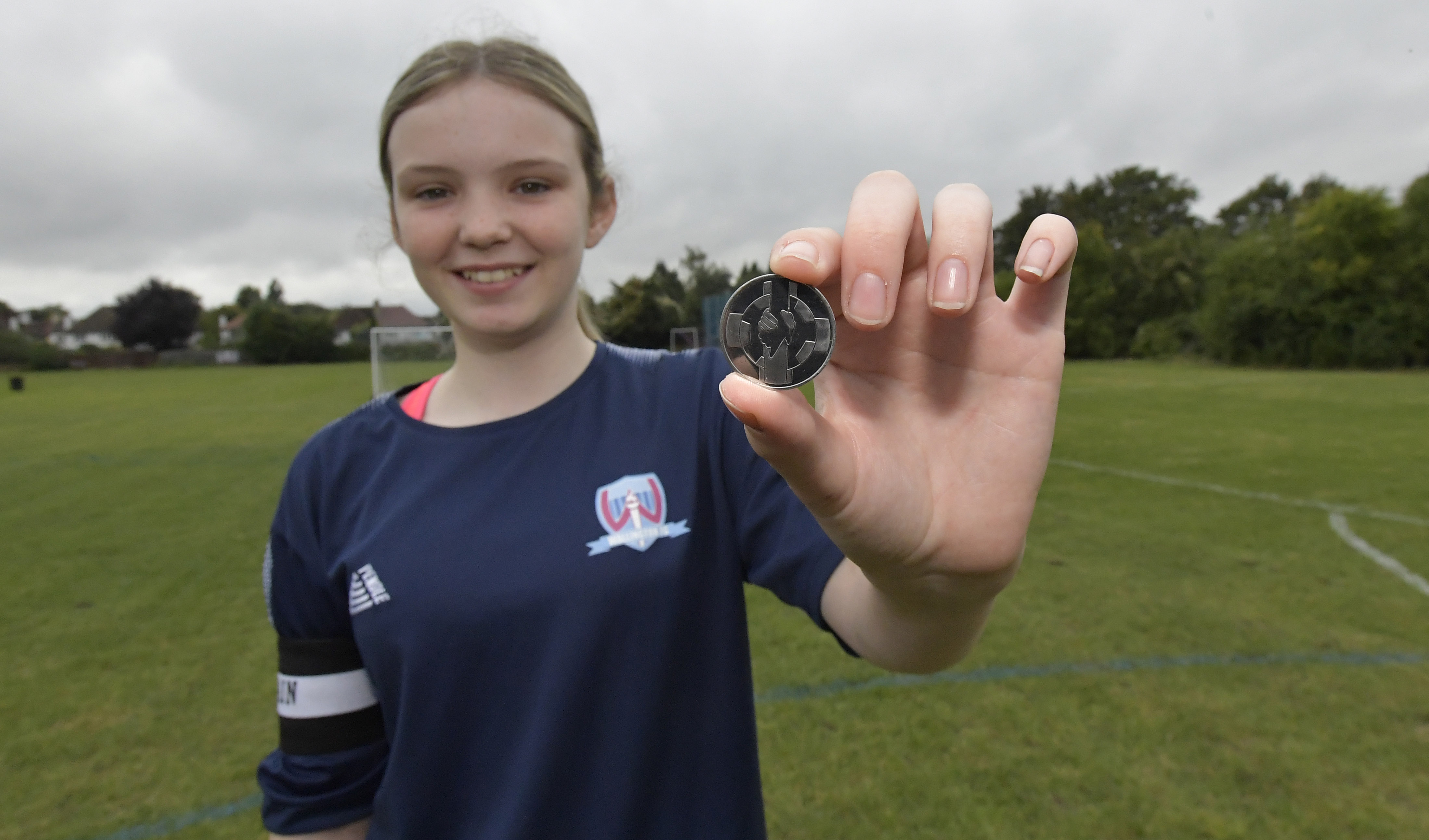 Competition winner Chloe displays her winning Coin for Respect design