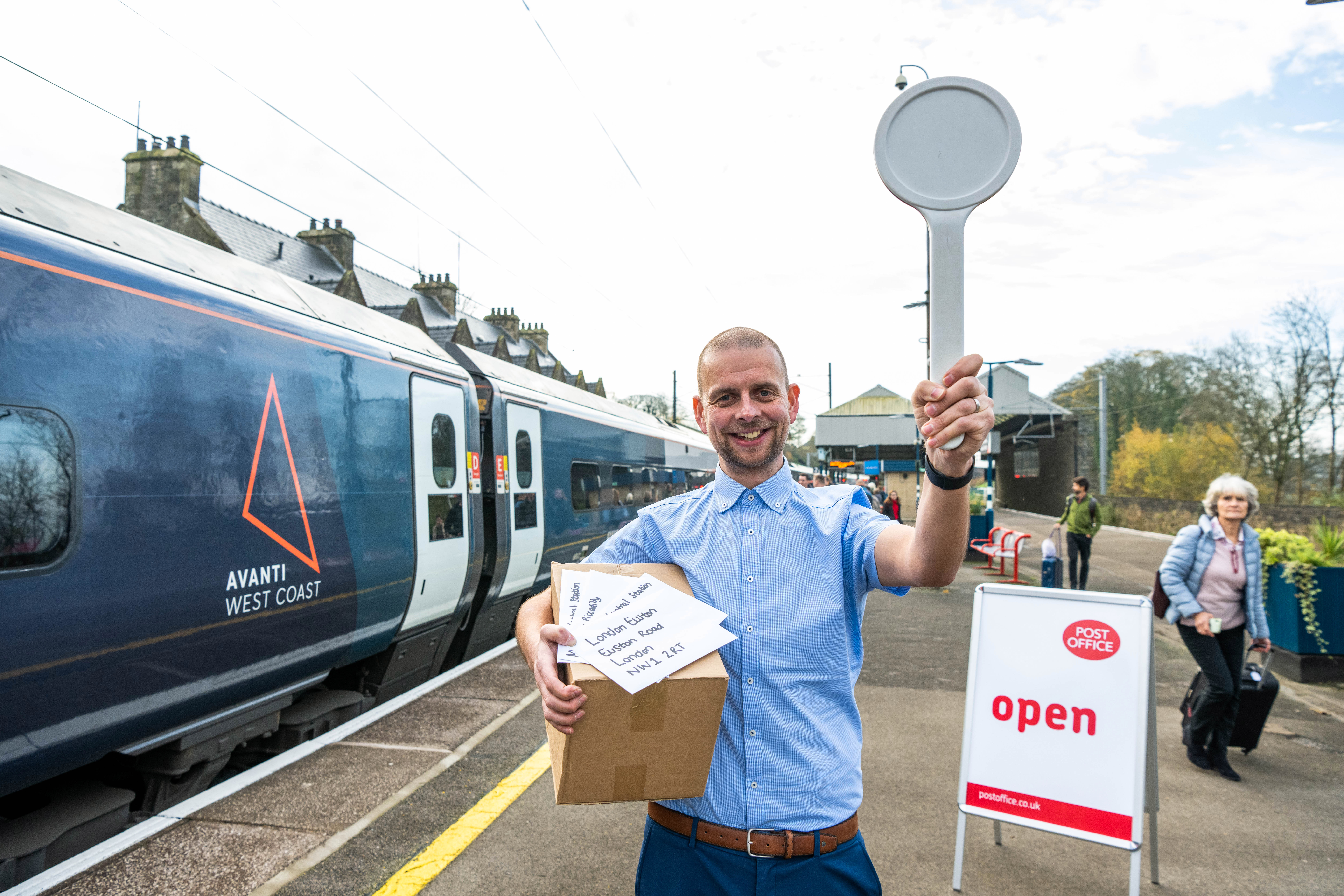 Postmaster Phil Ballantyne on a platform at Oxenholme station
