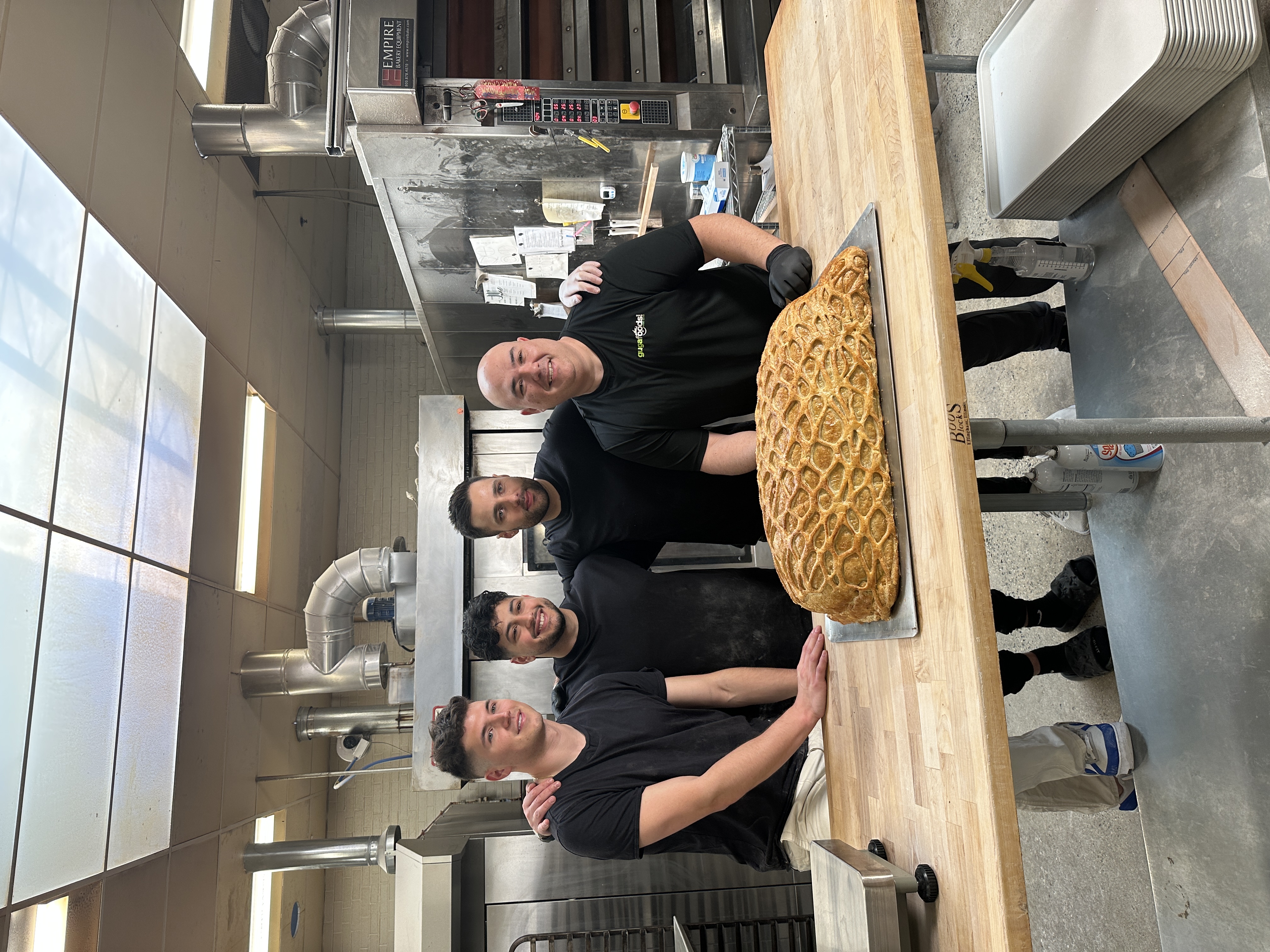 (Left to right) TikTok stars Nick DiGiovanni, The Golden Balance, Max the Meat Guy and Guga Foods stood in a kitchen in front of the world's largest beef wellington laid on a table