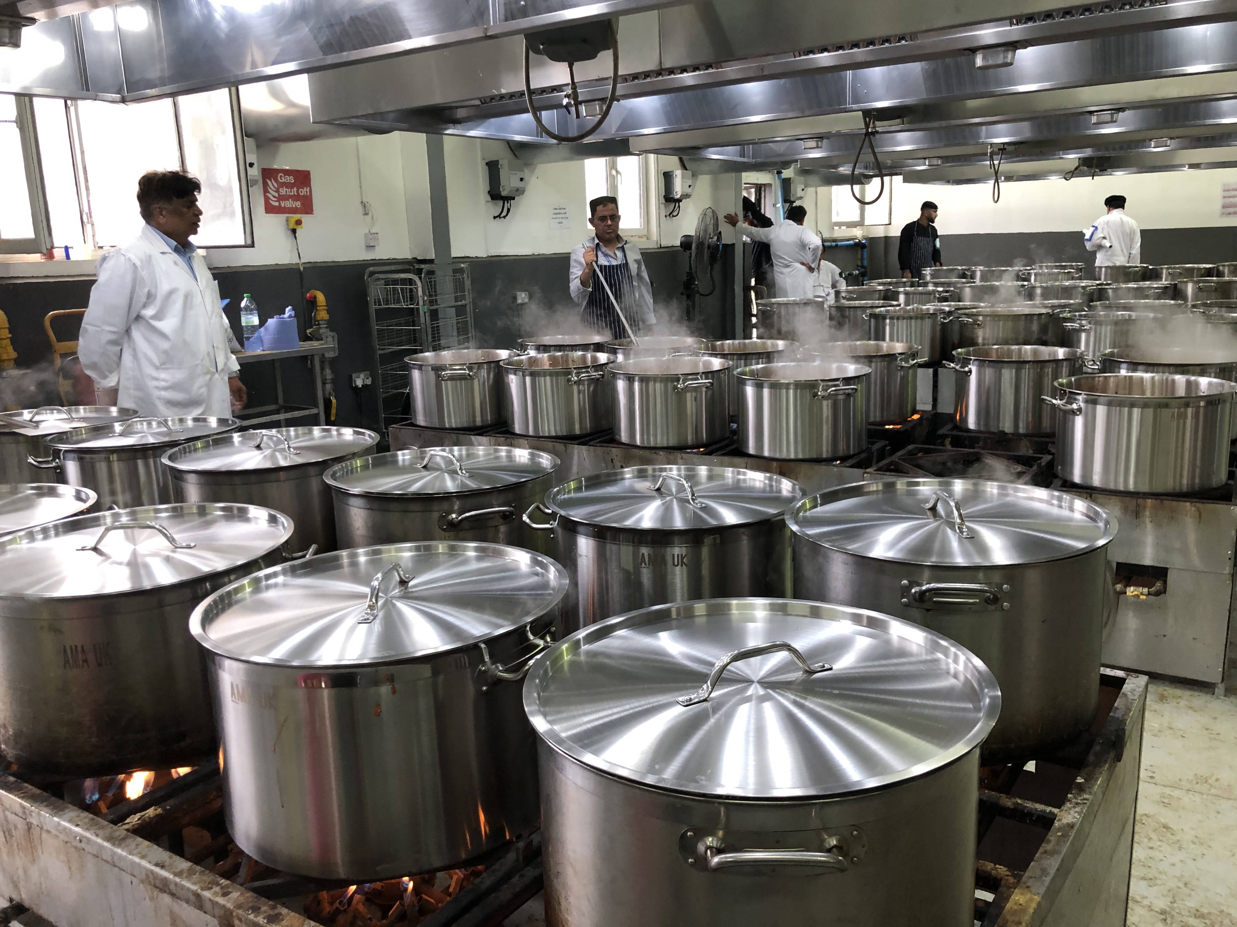 Several large metal pots where meals are cooked onsite by volunteers
