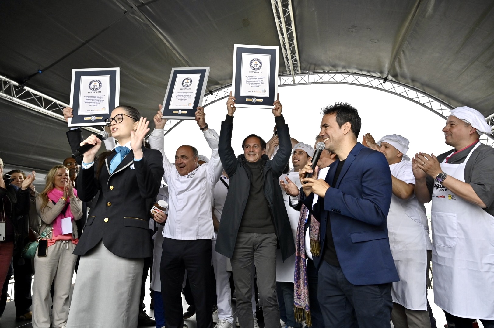 A group of people cheering with their Guinness World Record certificates 