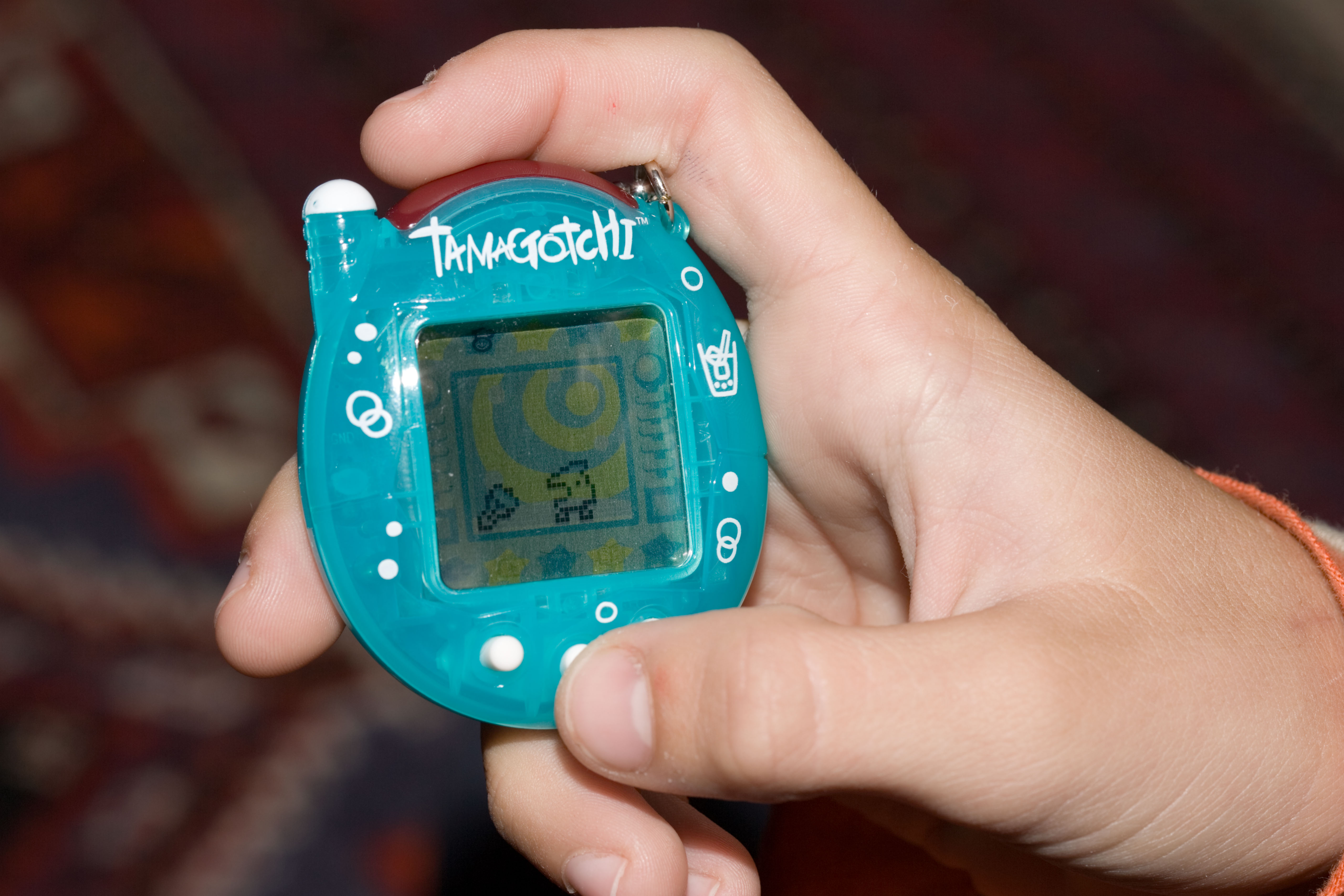 A Tamagotchi held in the hand of young boy