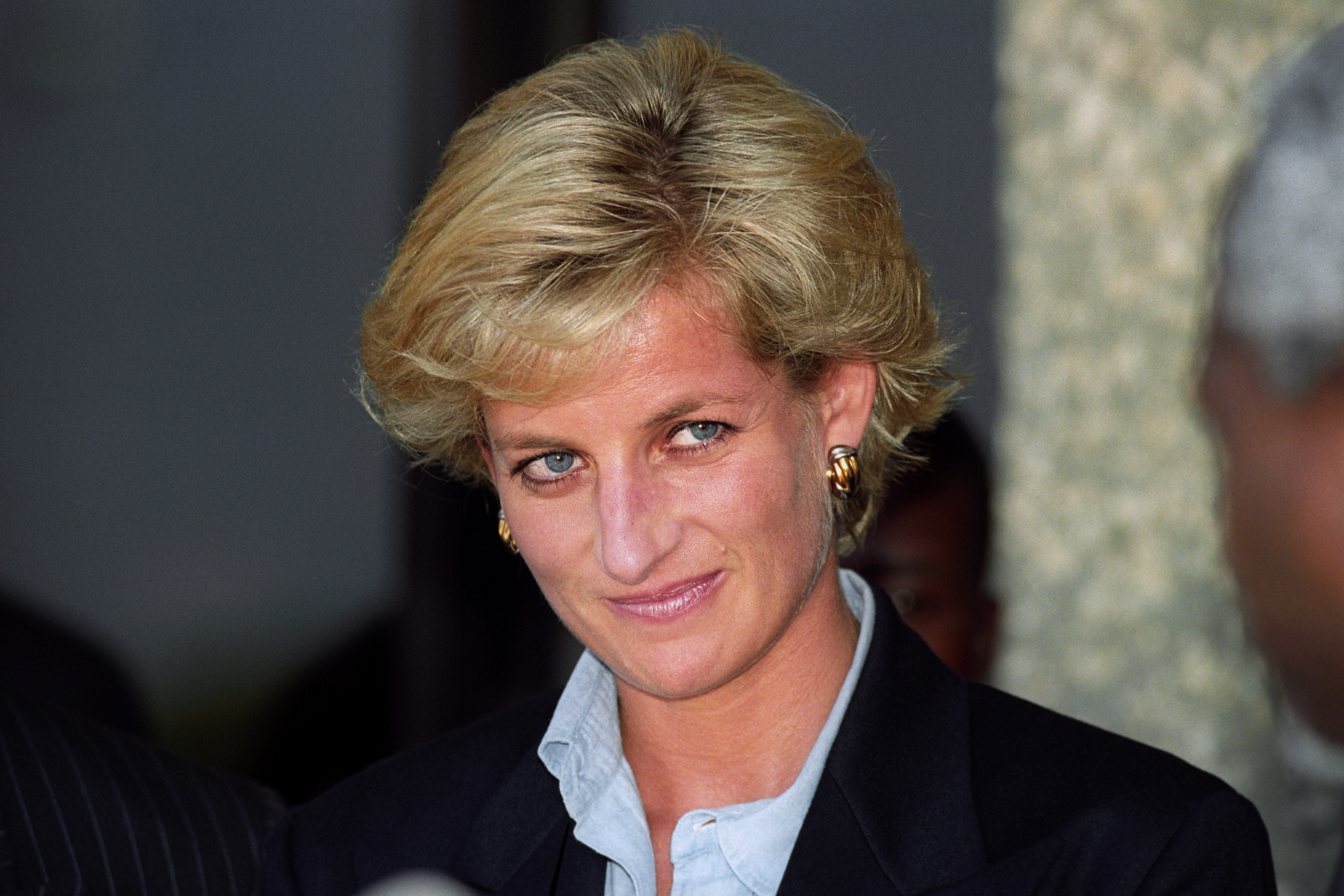 Head and shoulders photo of Diana, Princess of Wales, wearing a black blazer over a shirt