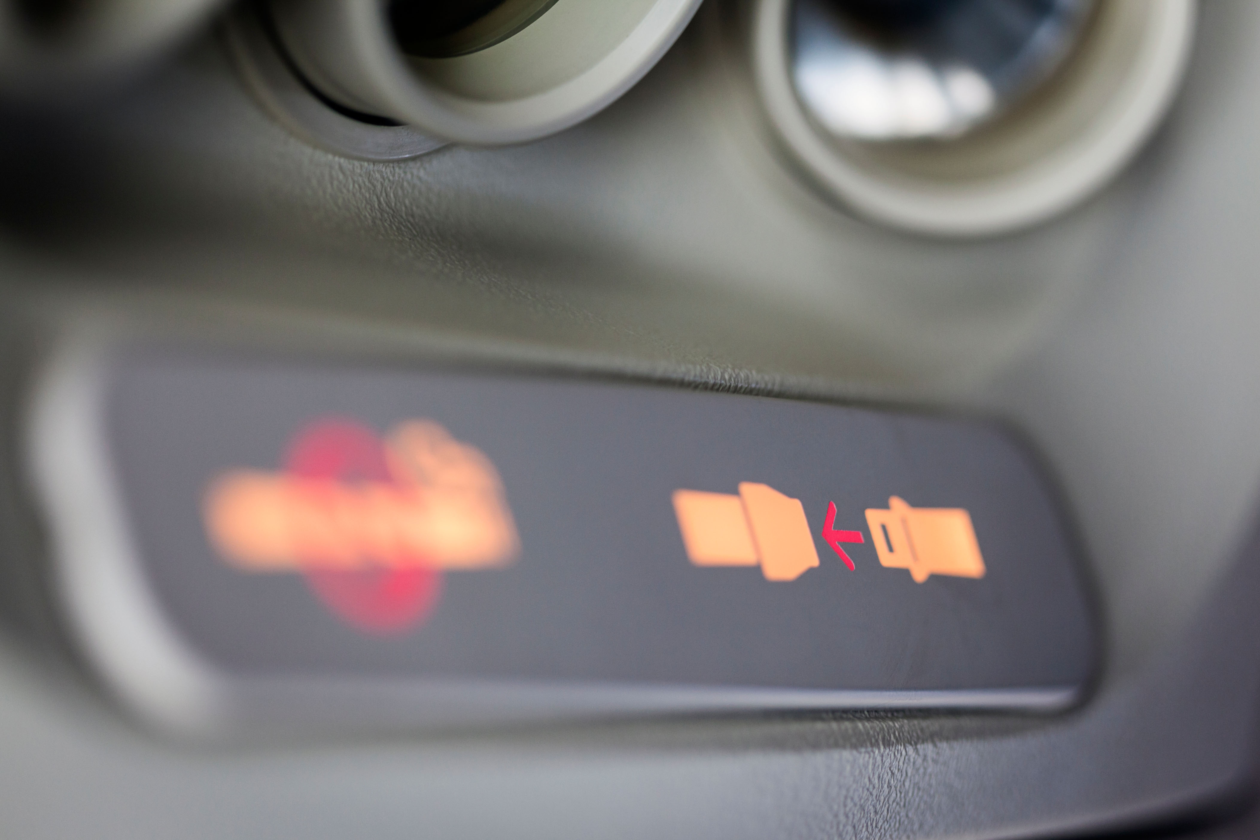 Close-up of the illuminated fasten seatbelt sign inside a plane