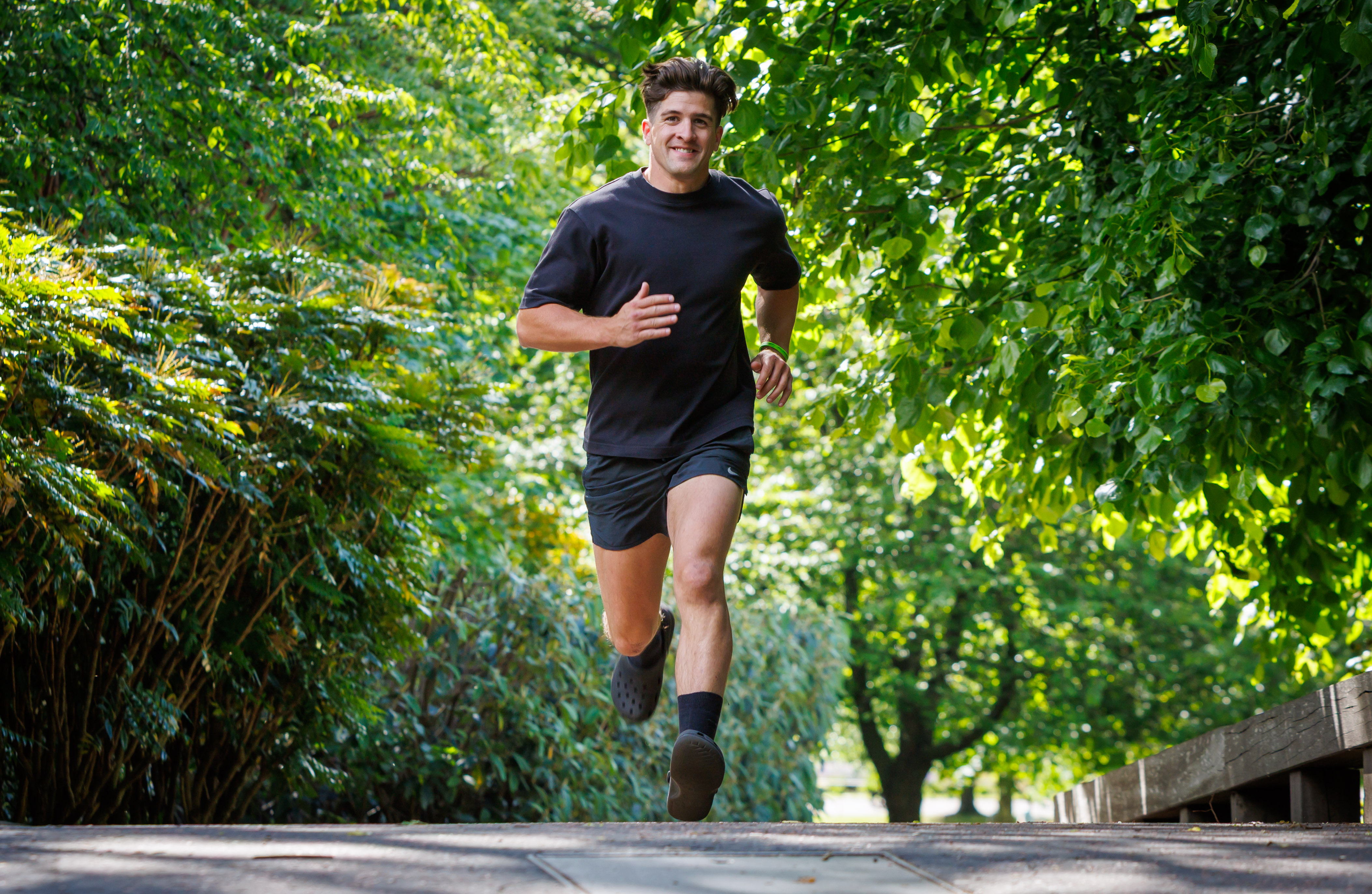 Danny Campbell smiling while running in black Crocs
