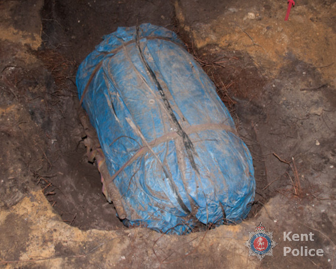 A barrel-shaped container wrapped in blue tarpaulin