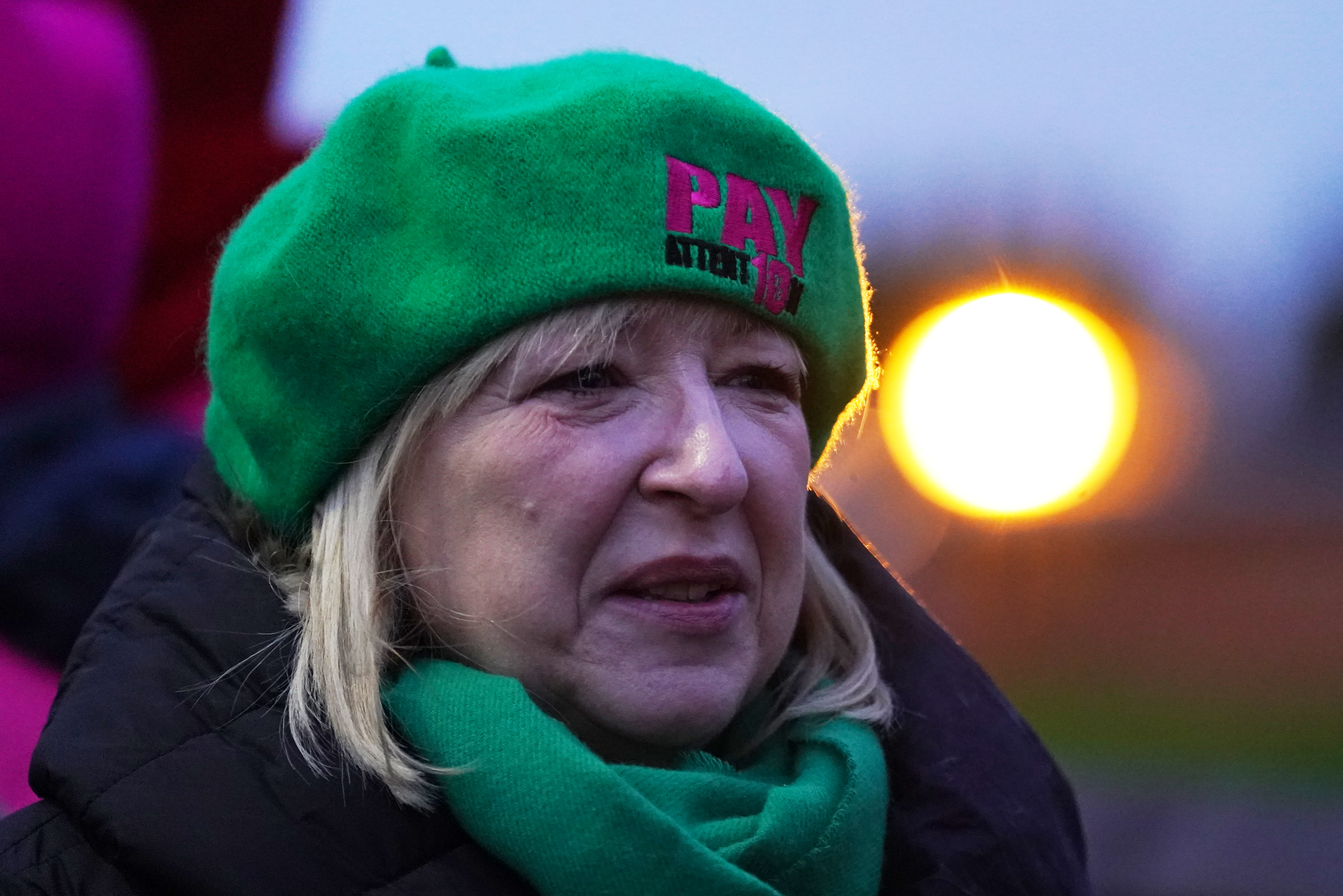 Headshot of Andrea Bradley wearing a green beret which says "Pay attent10n' on it