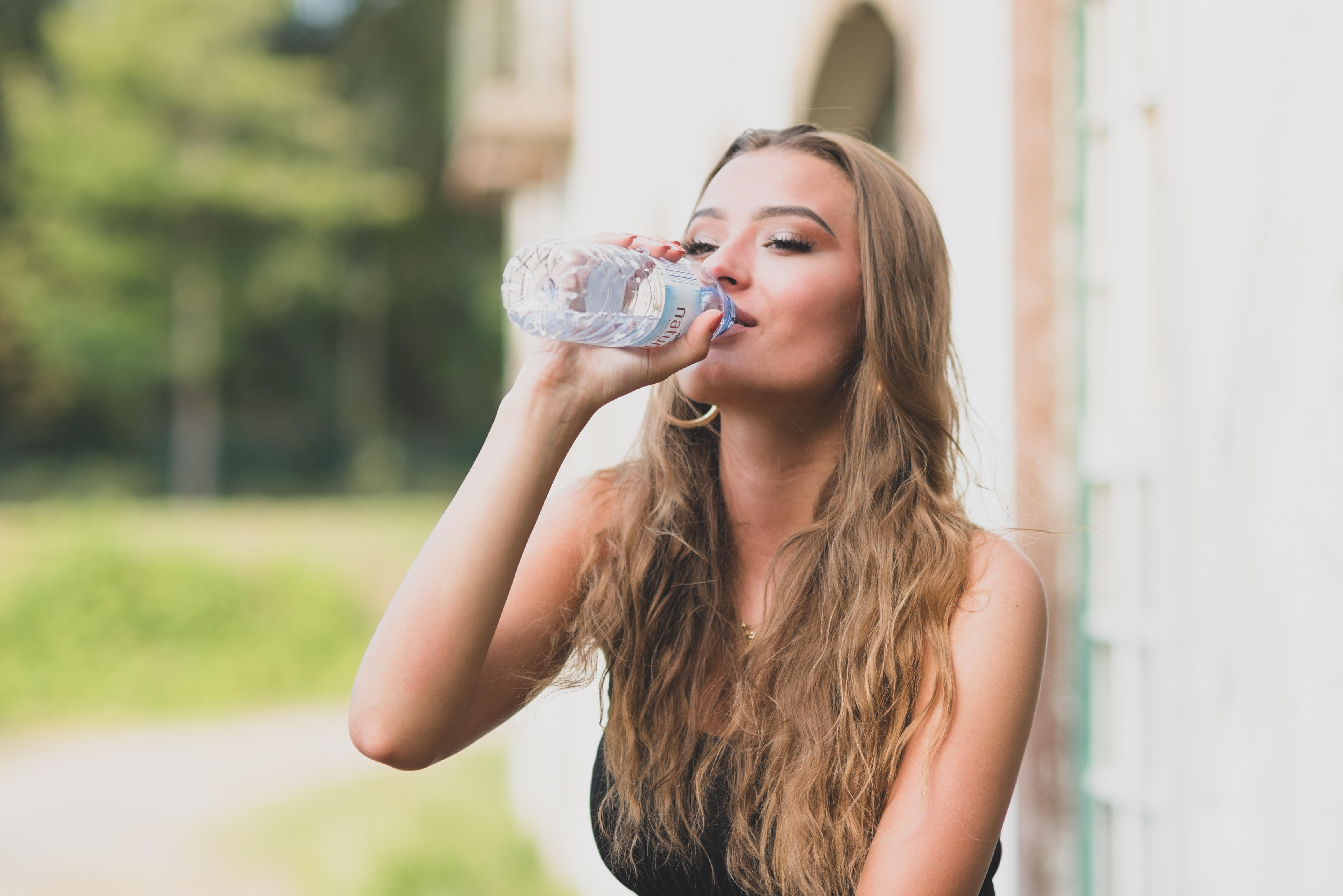 young girl drinking from water bottle
