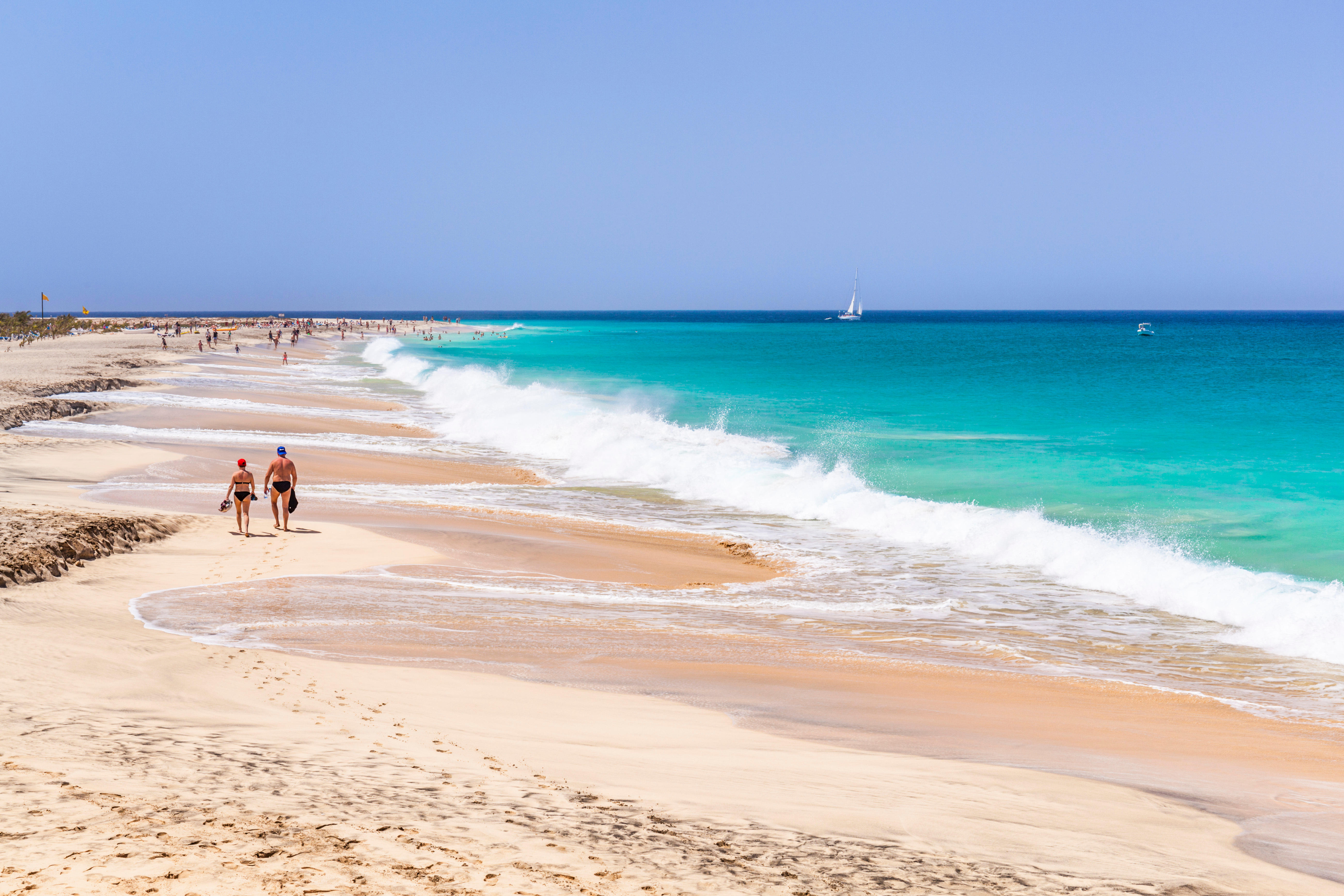 Tourists walking along a sandy beach in Cape Verde