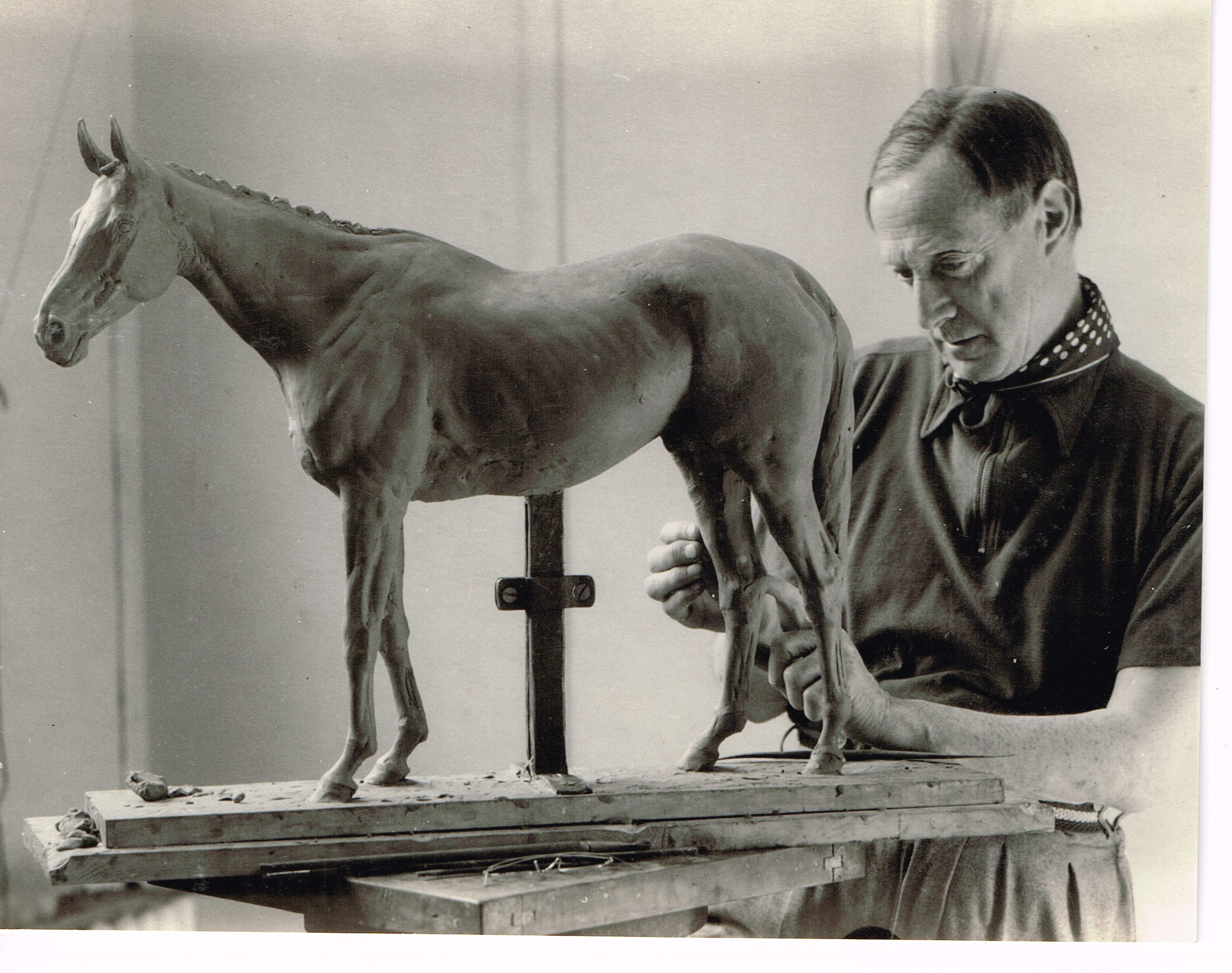 Black and white photo of Sir Alfred Munnings creating a horse sculpture