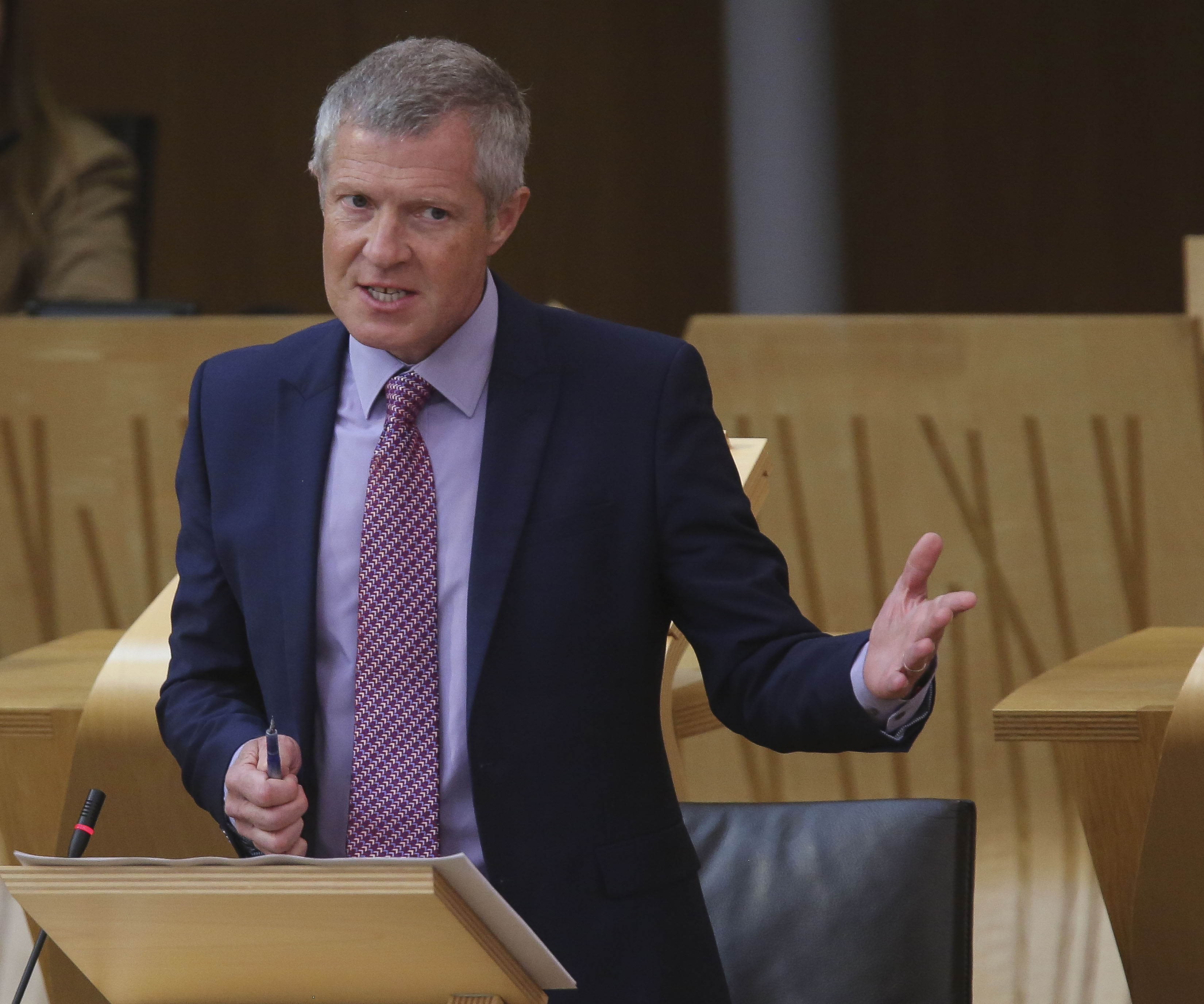 Willie Rennie gesturing with one arm while speaking in Holyrood