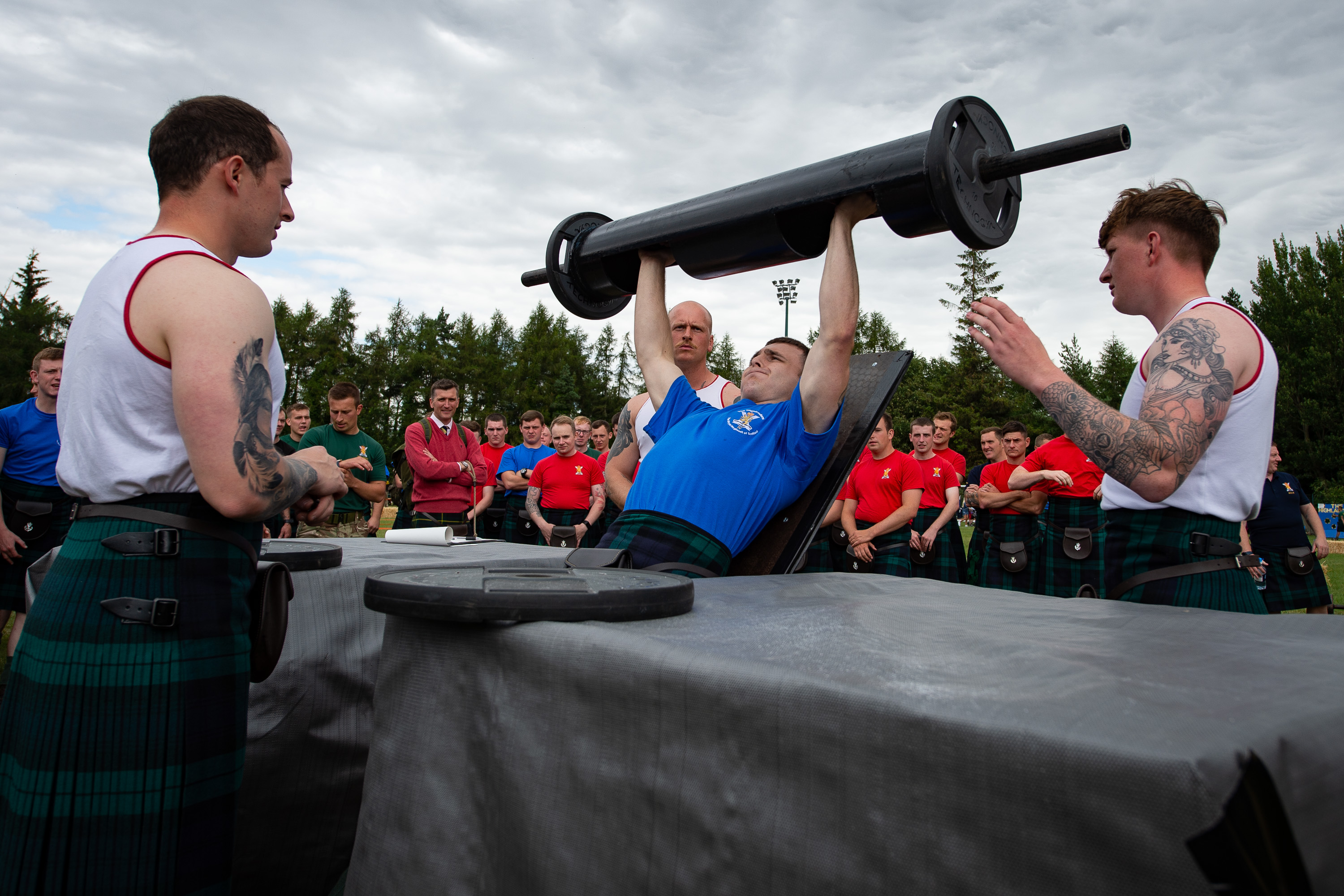 Soldiers doing weightlifting while wearing kilts
