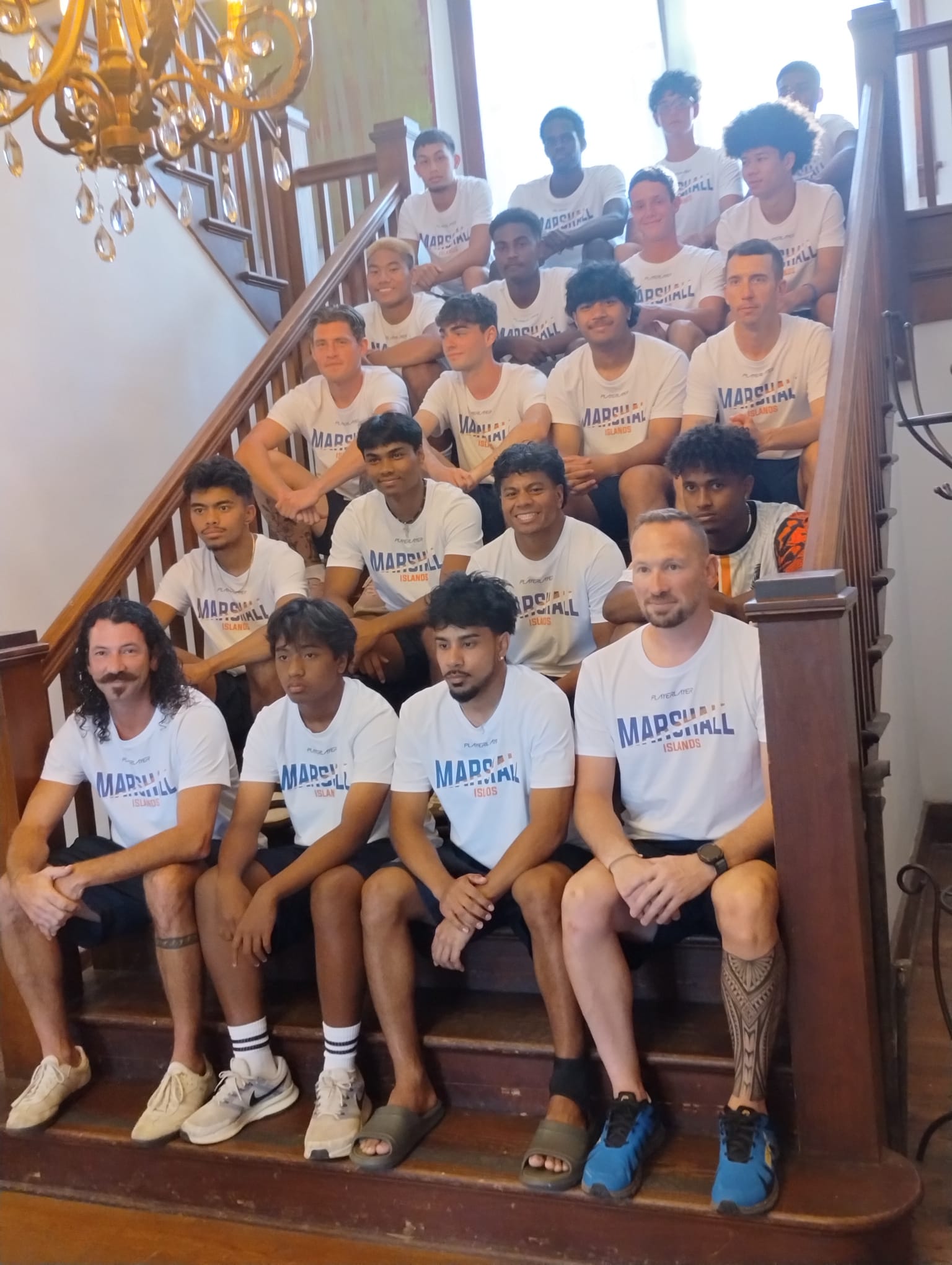 Members of the Marshall Islands football team pose on the stairs