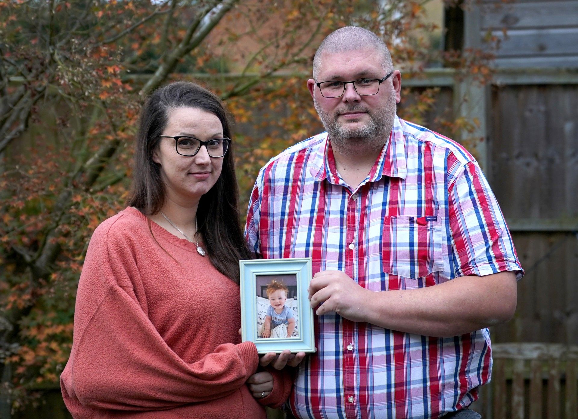 Zoe and Lewis Steeper holding a picture of their son Oliver