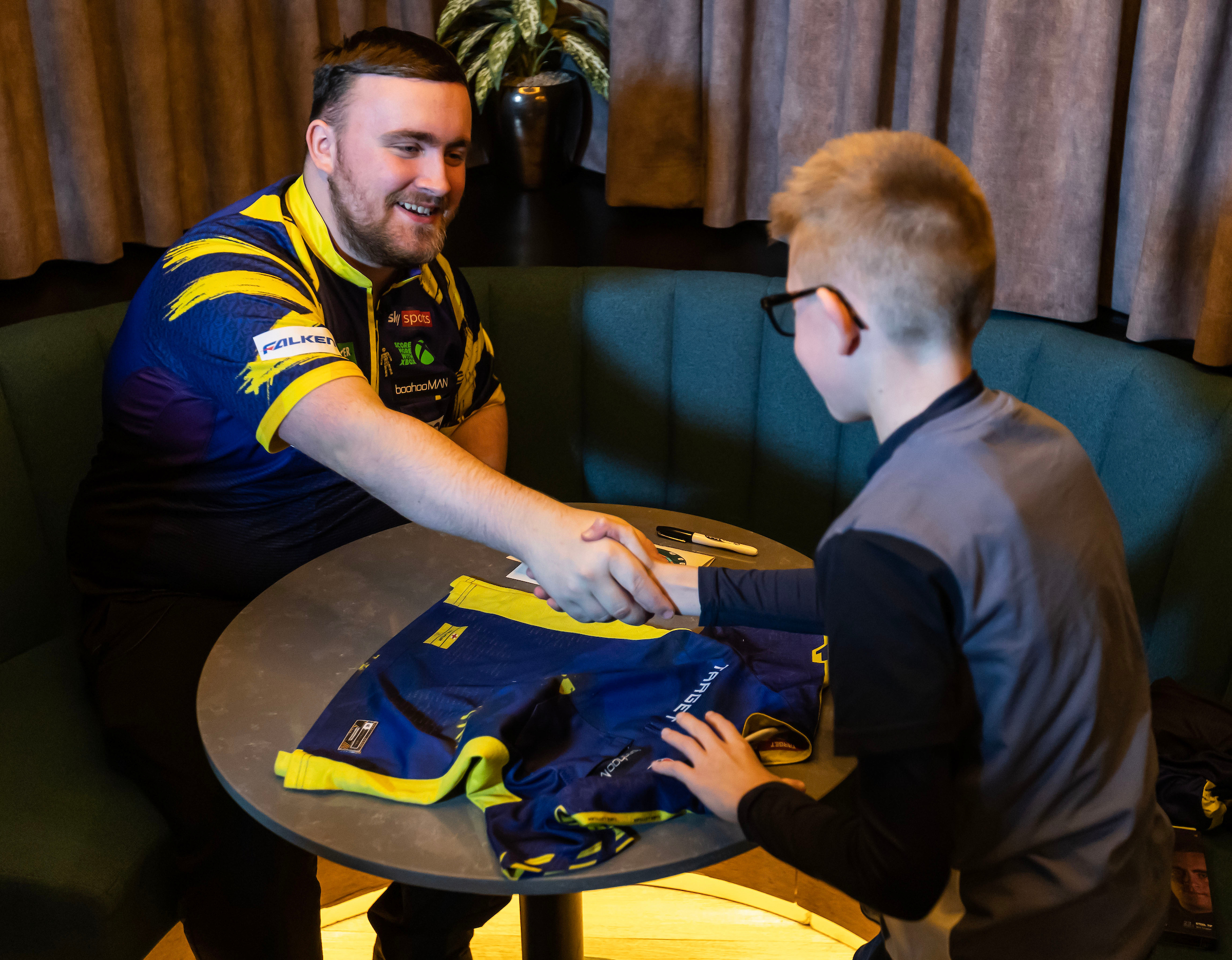 Luke Littler (left) shakes hands with a superfan