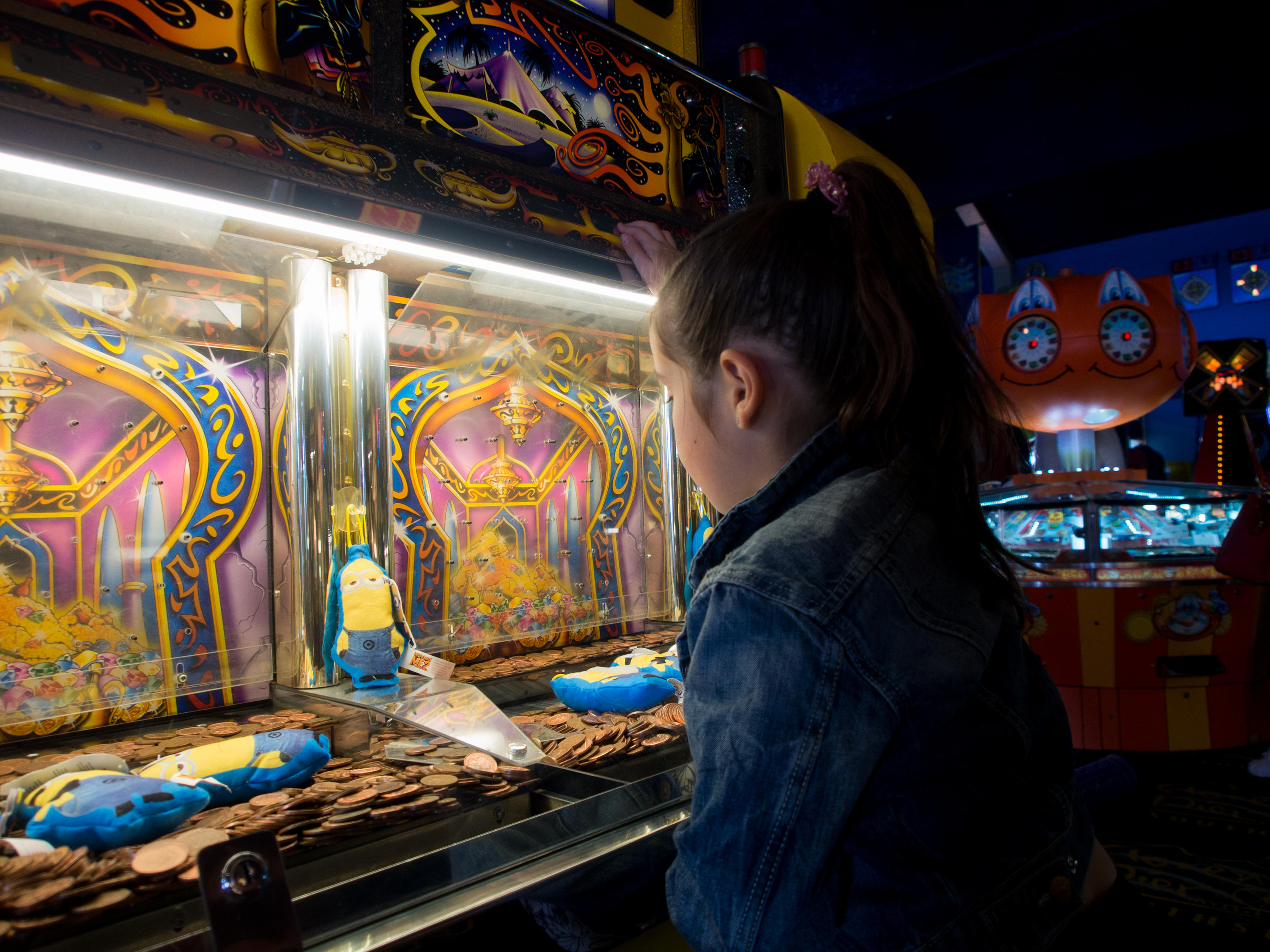 A young girl playing a slot machine in an amusement arcade