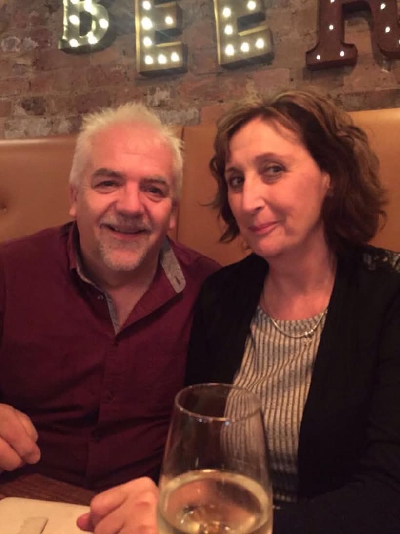 Karen Pooley and her husband smiling while seated in a bar