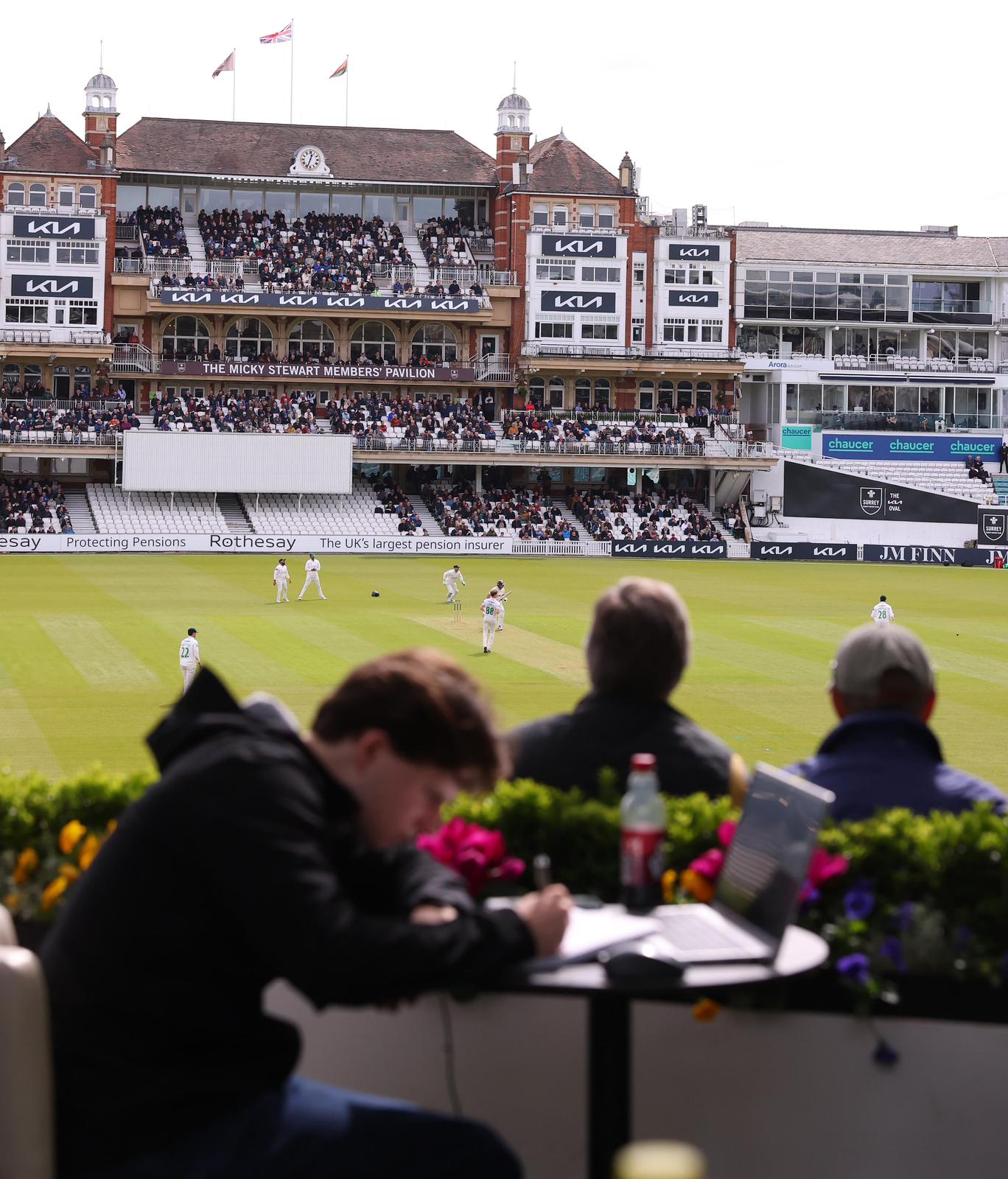 A fan works at his laptop while watching Surrey v Leicestershire.