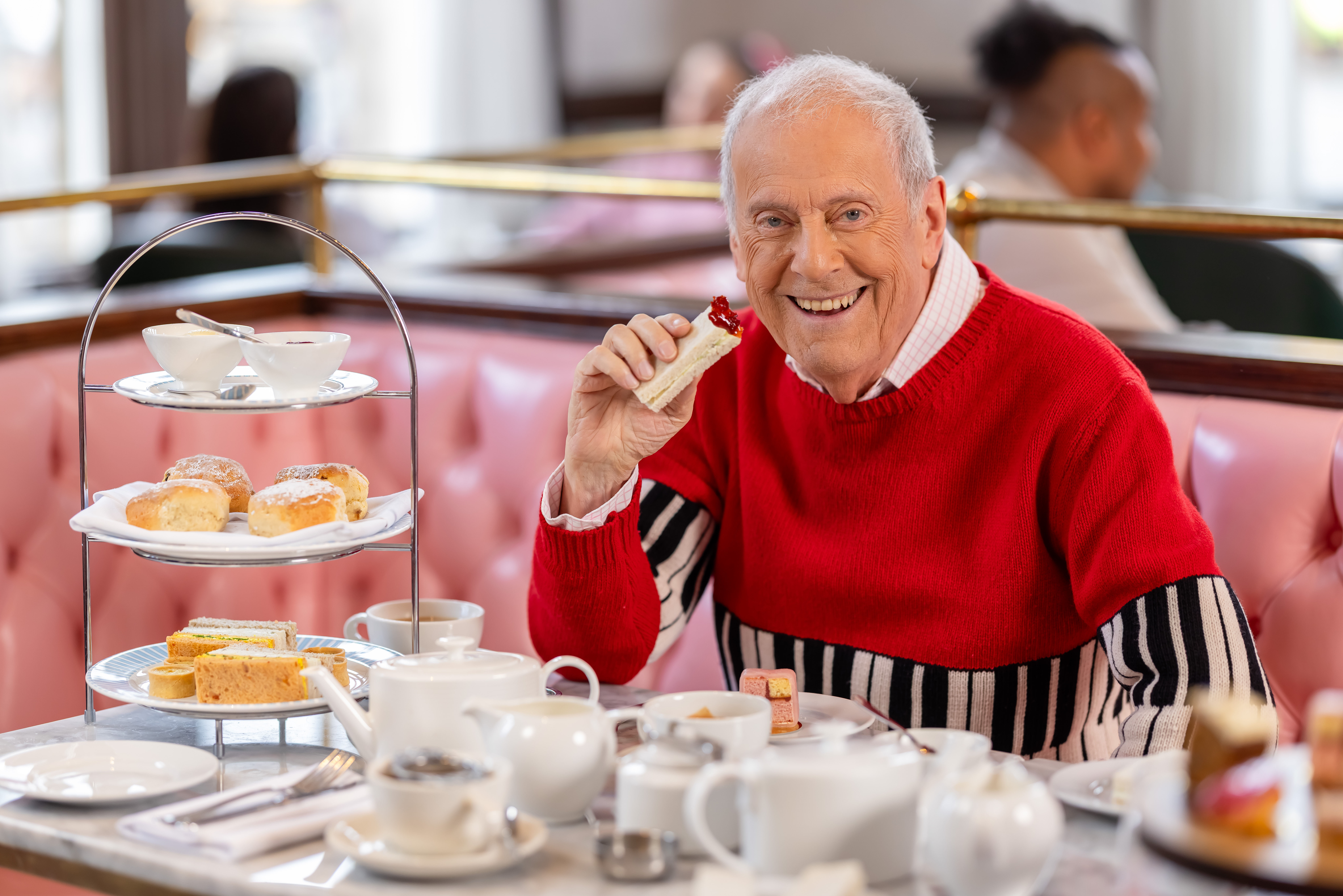 Gyles Brandreth with an afternoon tea platter ( Hilton/Ollie Dixon/PA)
